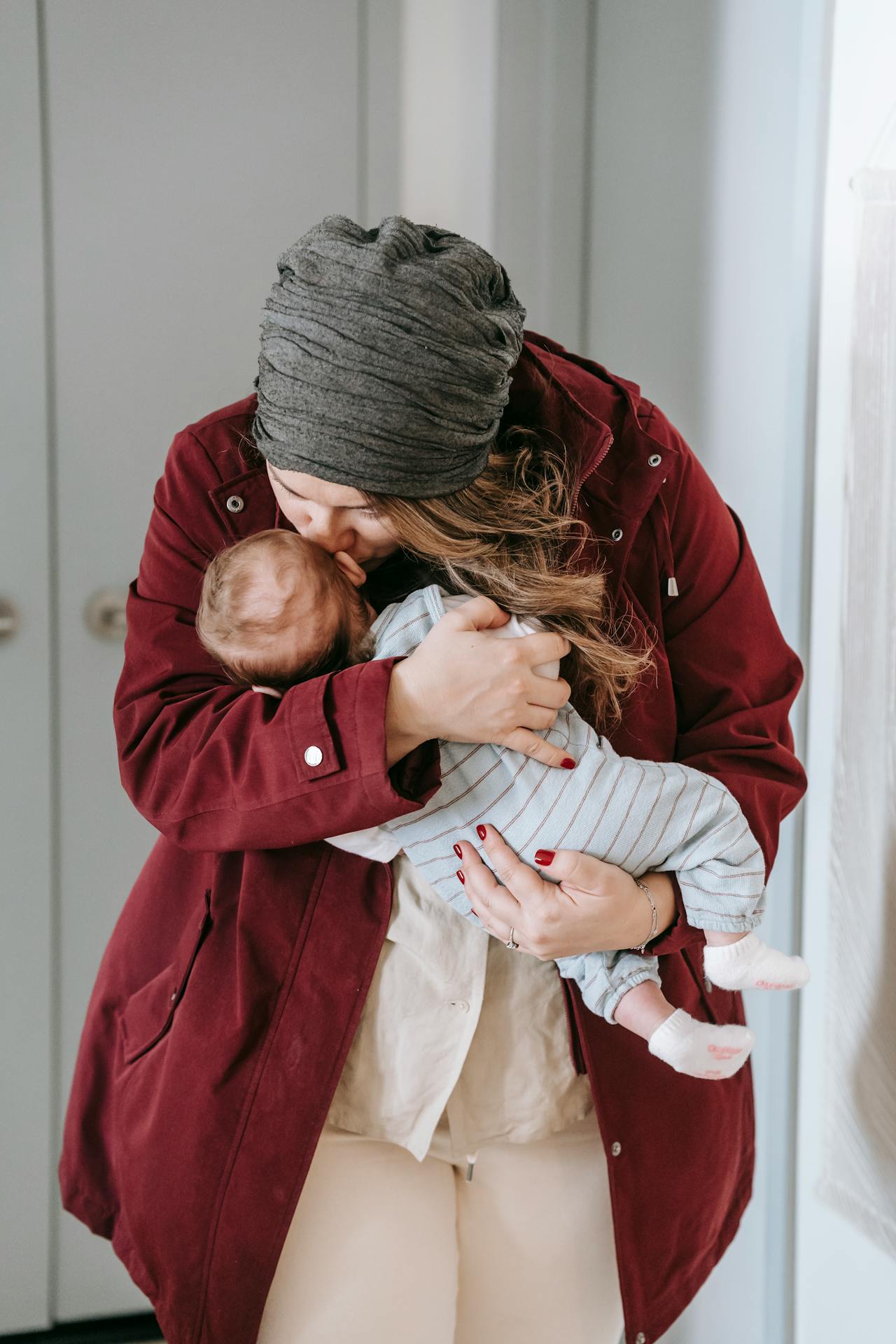 Une mère embrassant son bébé sur le front | Source : Pexels