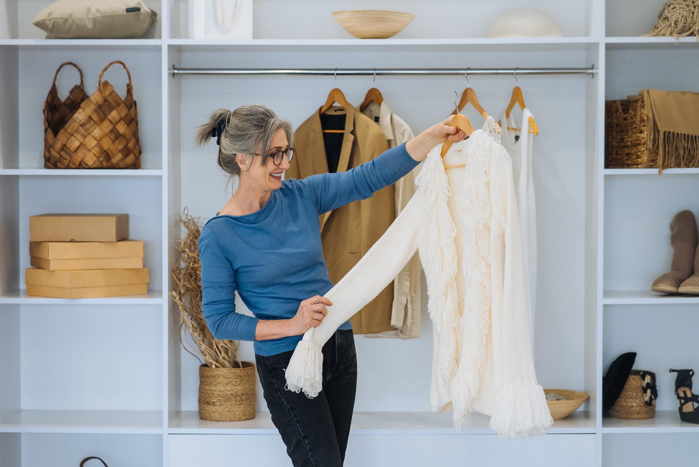 Femme âgée choisissant une tenue dans son placard | Source : Freepik