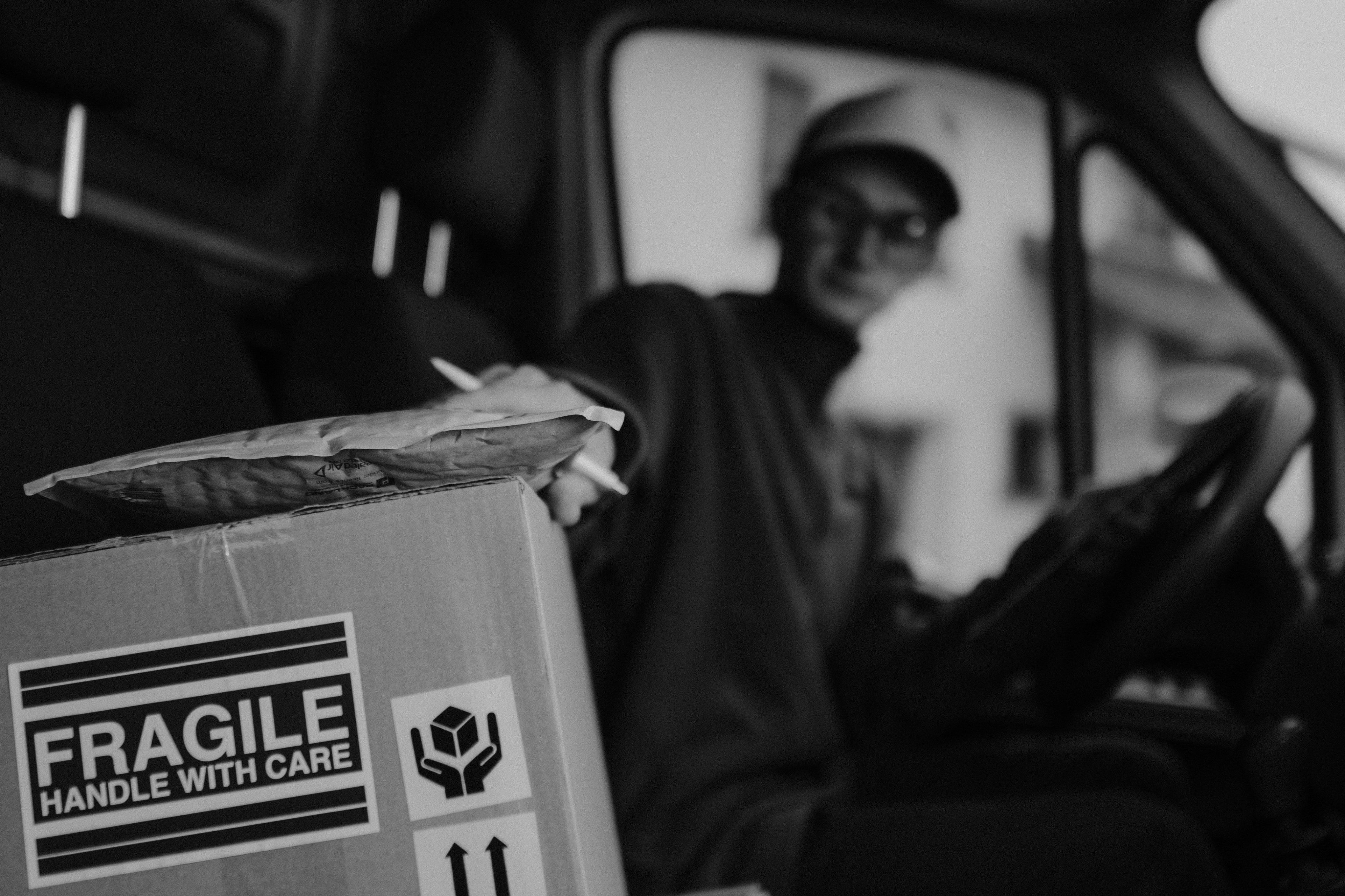 Un livreur en train de manipuler un colis | Source : Pexels