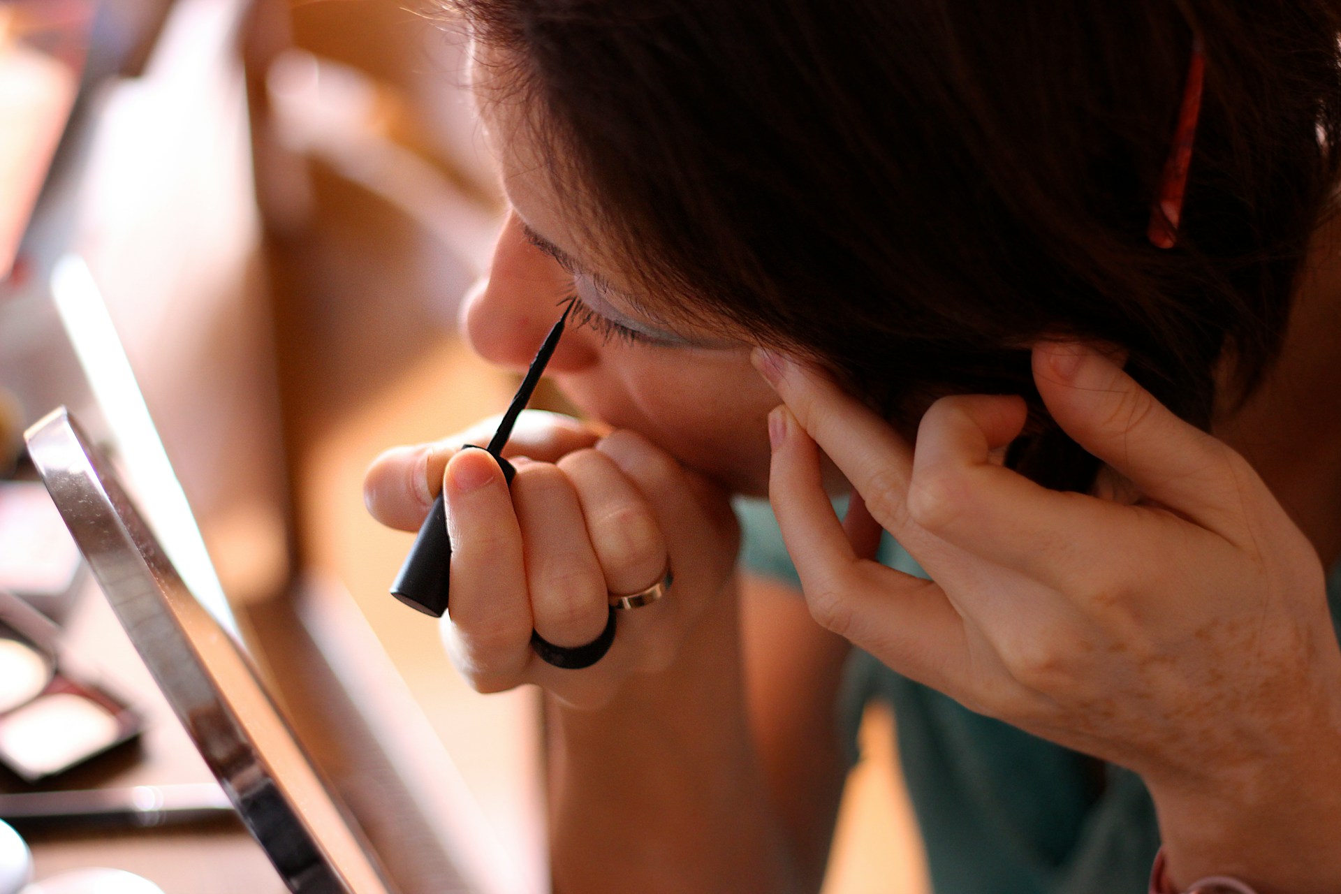 Une femme se regardant dans le miroir et appliquant de l'eyeliner | Source : Unsplash