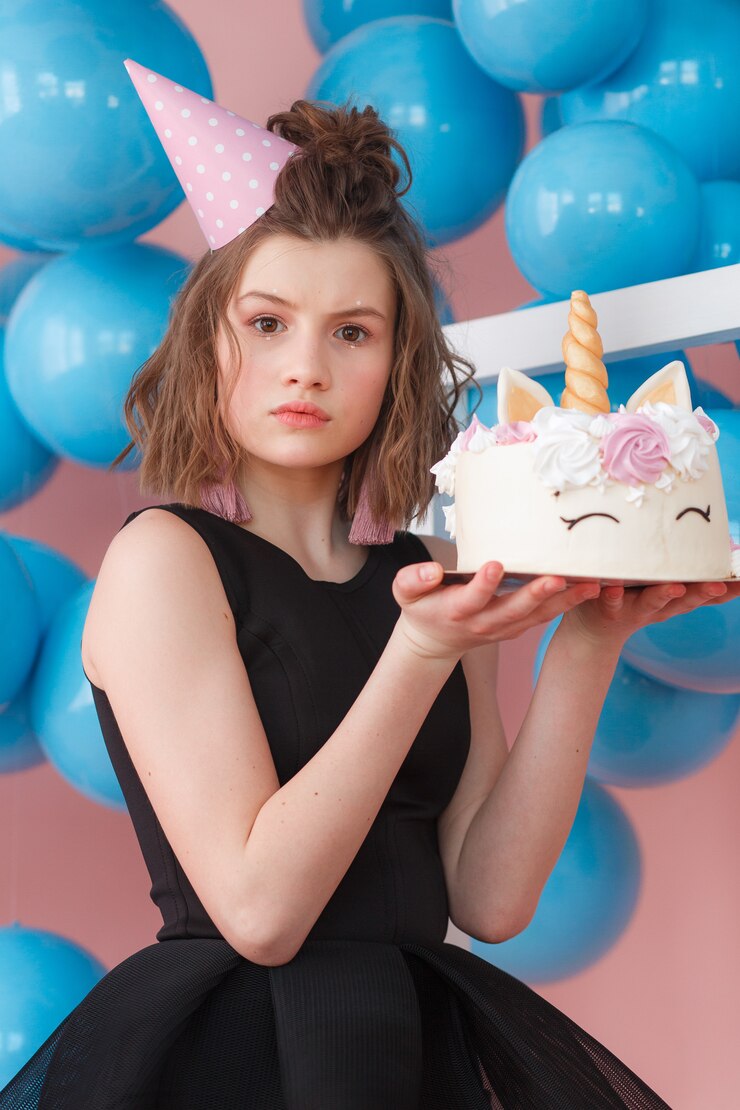 Une fille qui fête son anniversaire avec un gâteau | Source : Freepik