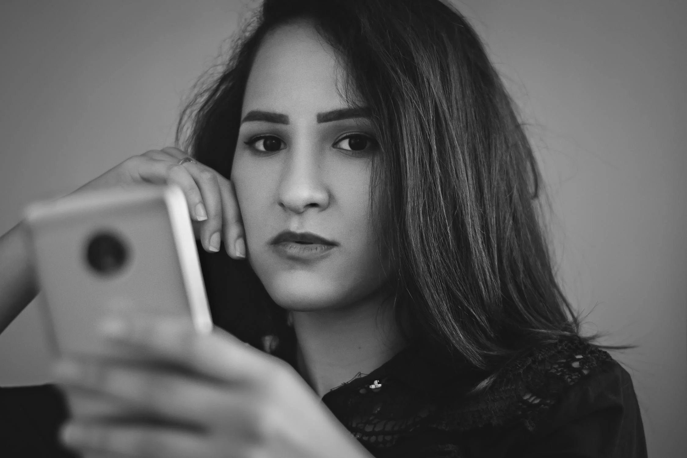 Une femme sérieuse avec un téléphone dans les mains | Source : Pexels