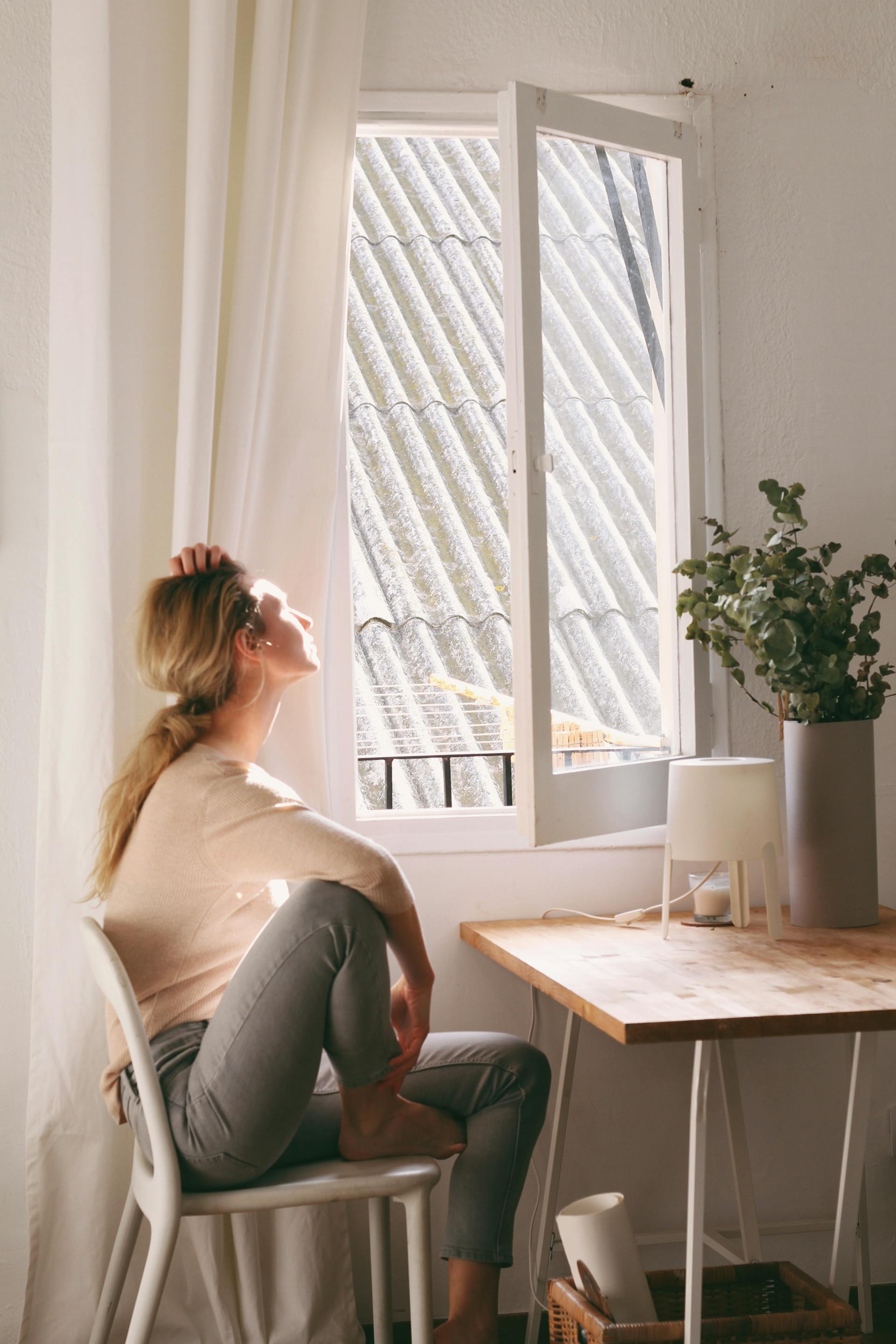 Une femme assise et regardant par la fenêtre | Source : Pexels