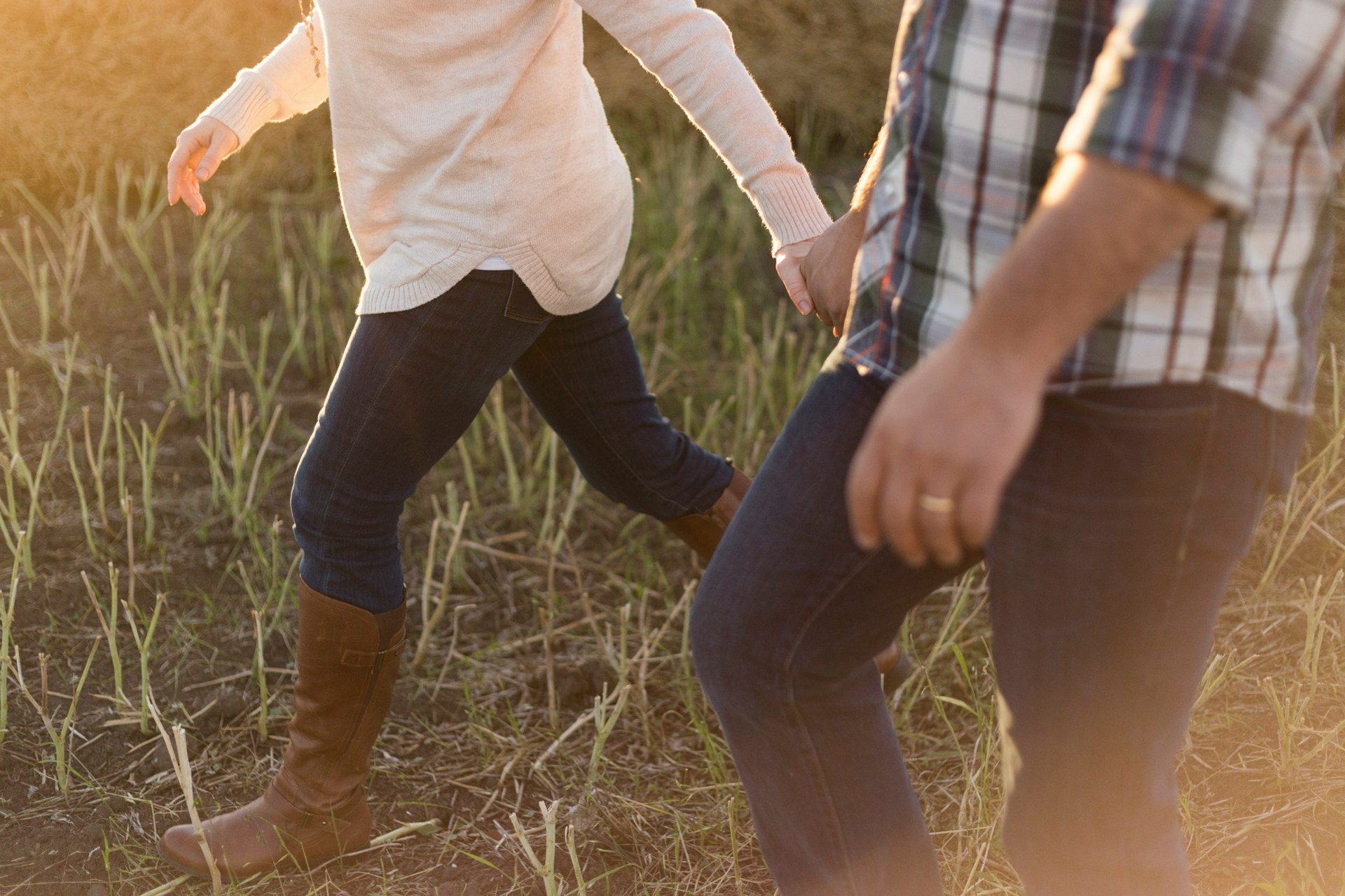 Un couple se tenant par la main dans un champ | Source : Unsplash