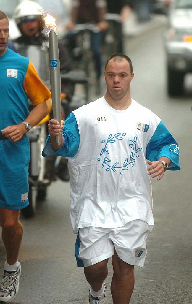 Pascal Duquenne courant avec la flamme Olympique en 2004. І Source : Getty Images