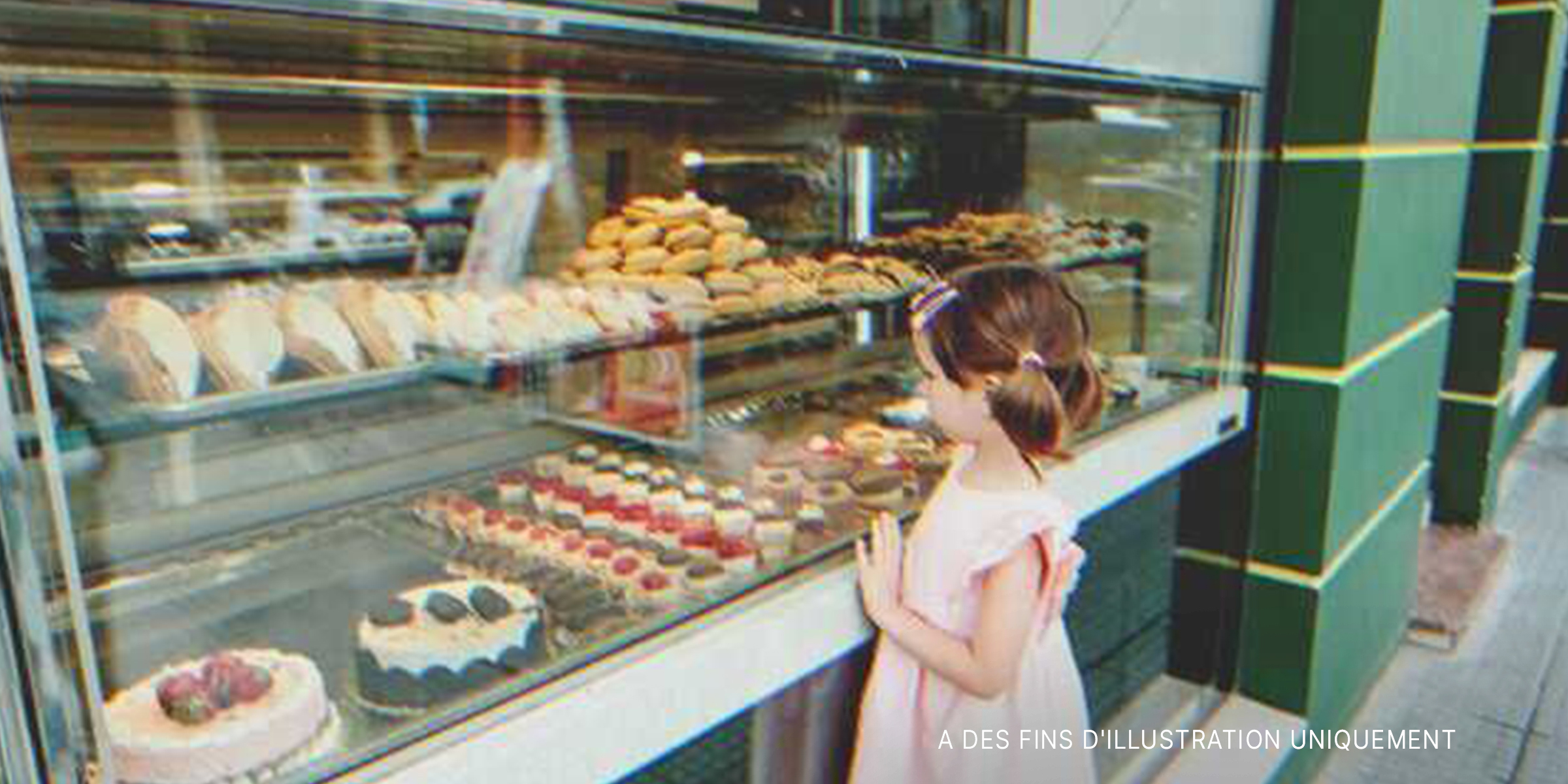 Une petite fille devant la vitrine d'une boulangerie | Source : Shutterstock