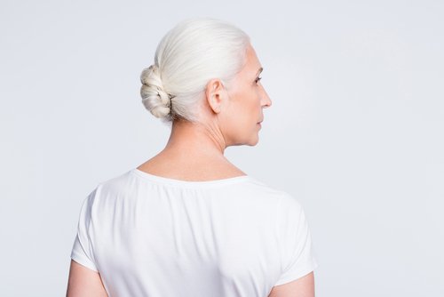 Une vieille dame les cheveux en chignon de dos | Photo : Getty Images.
