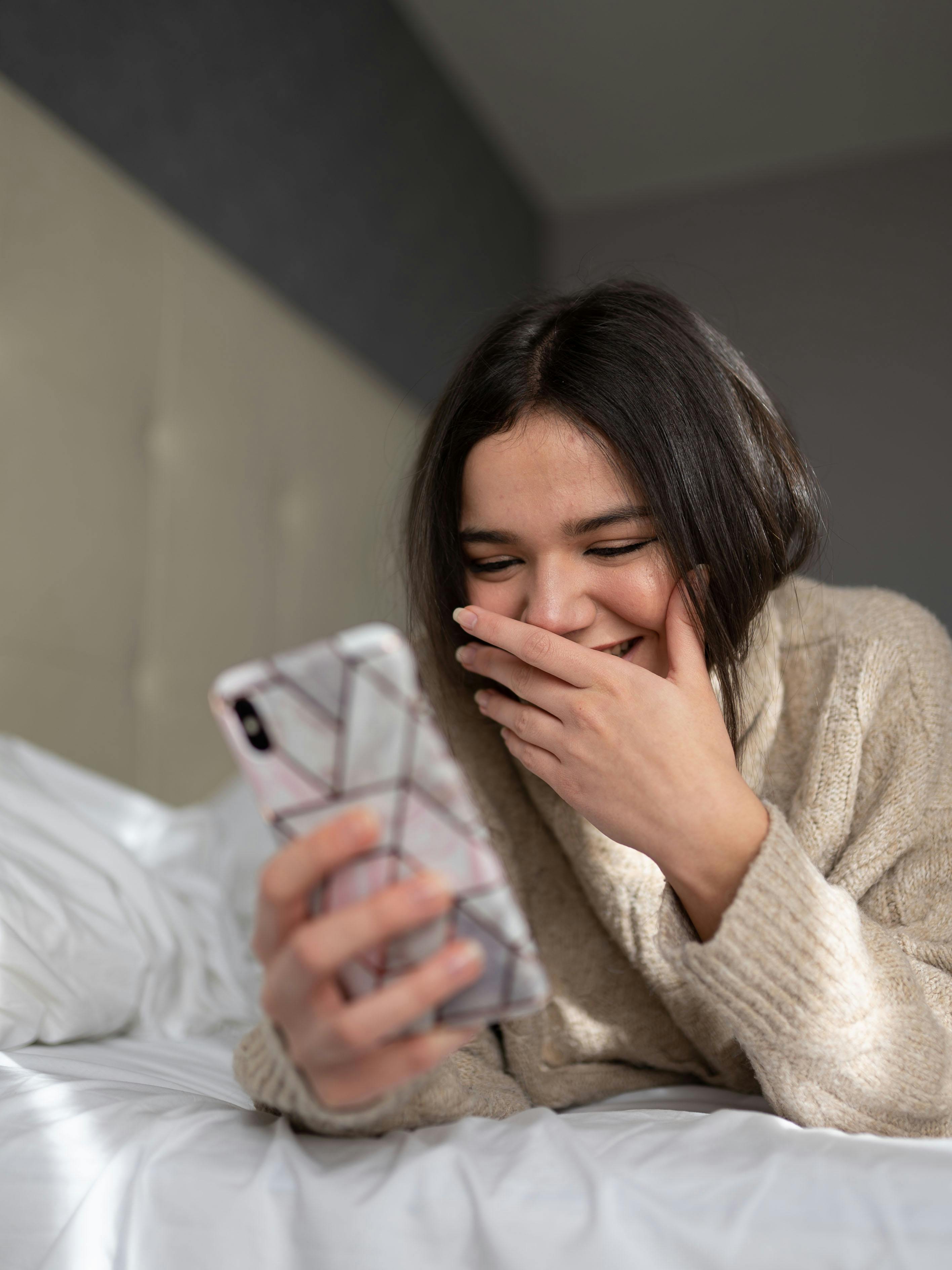 Une femme heureuse qui utilise son téléphone | Source : Pexels