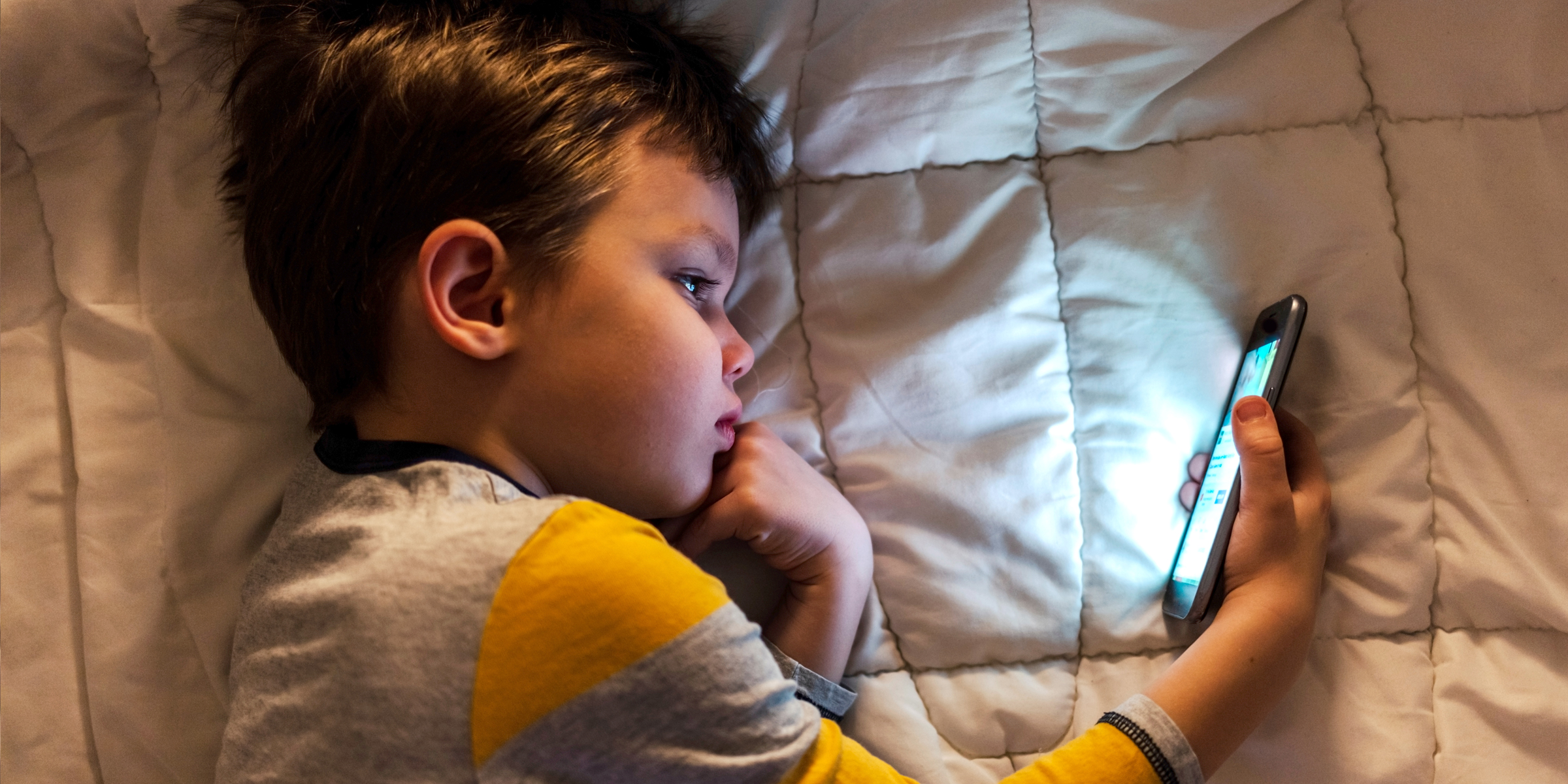 Un petit garçon regardant un téléphone portable | Source : Shutterstock