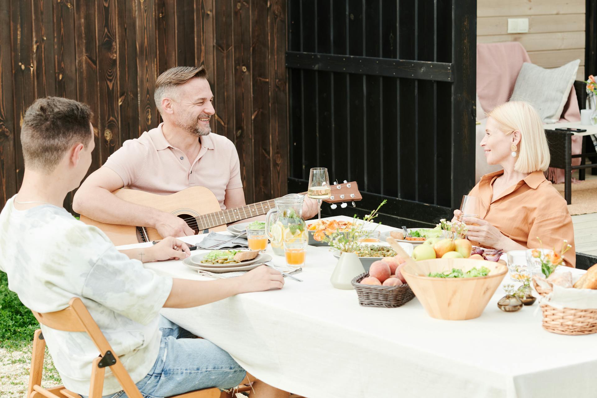 Un homme jouant de la guitare pendant un dîner en famille | Source : Pexels