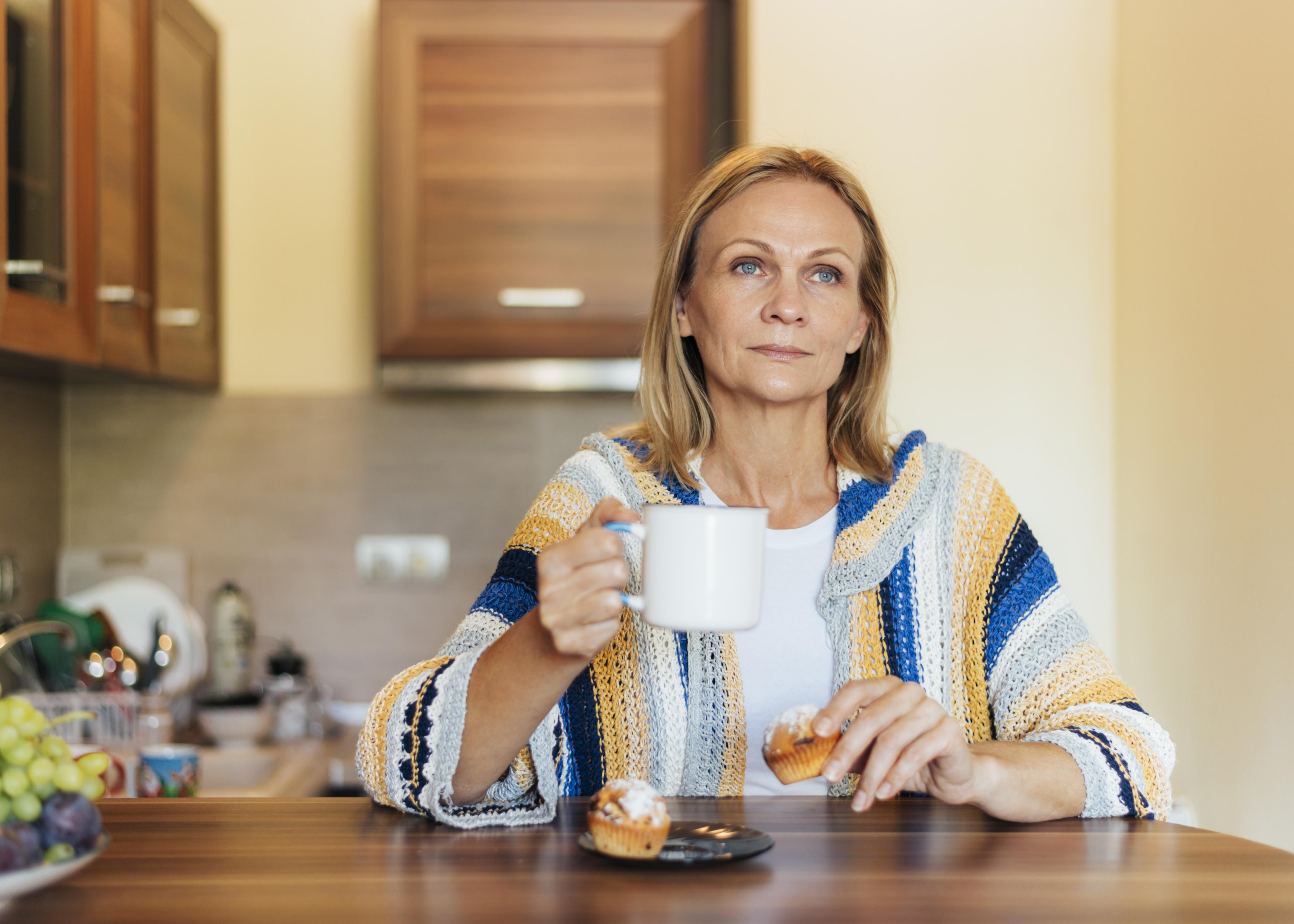 Femme dans la cuisine avec une tasse de thé | Source : Freepik