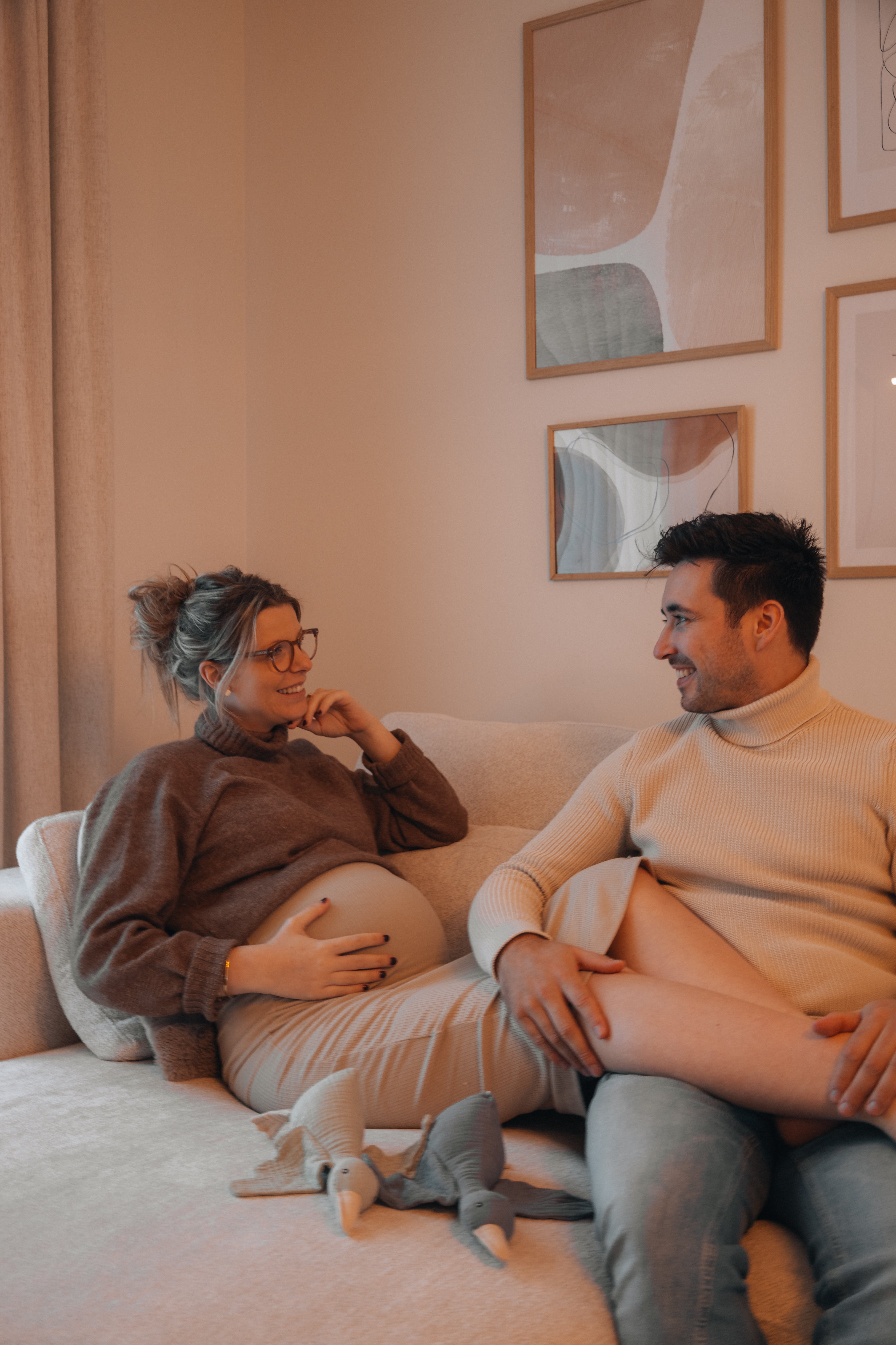 Une femme enceinte est assise avec ses jambes posées sur son mari | Source : Pexels