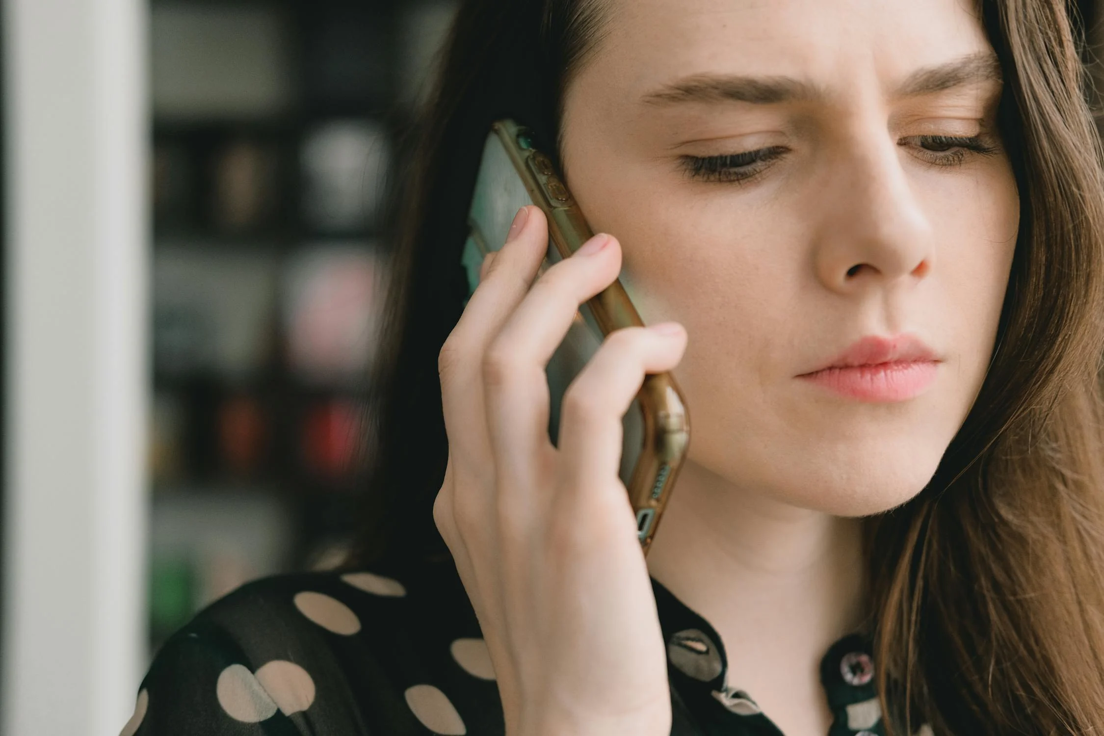 Une femme sérieuse qui parle au téléphone | Source : Pexels