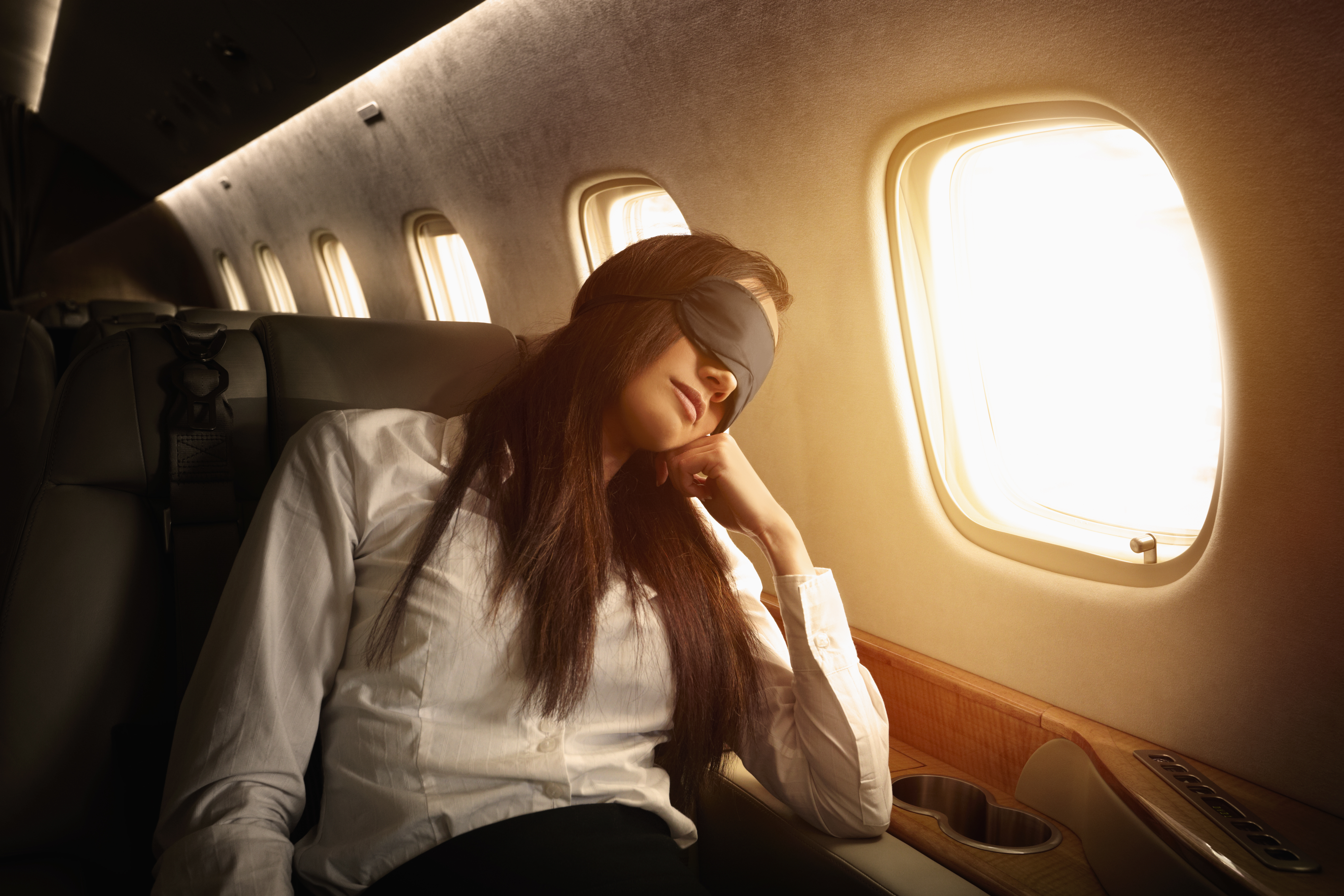 Femme d'affaires originaire des îles du Pacifique dormant dans un jet privé | Source : Getty Images