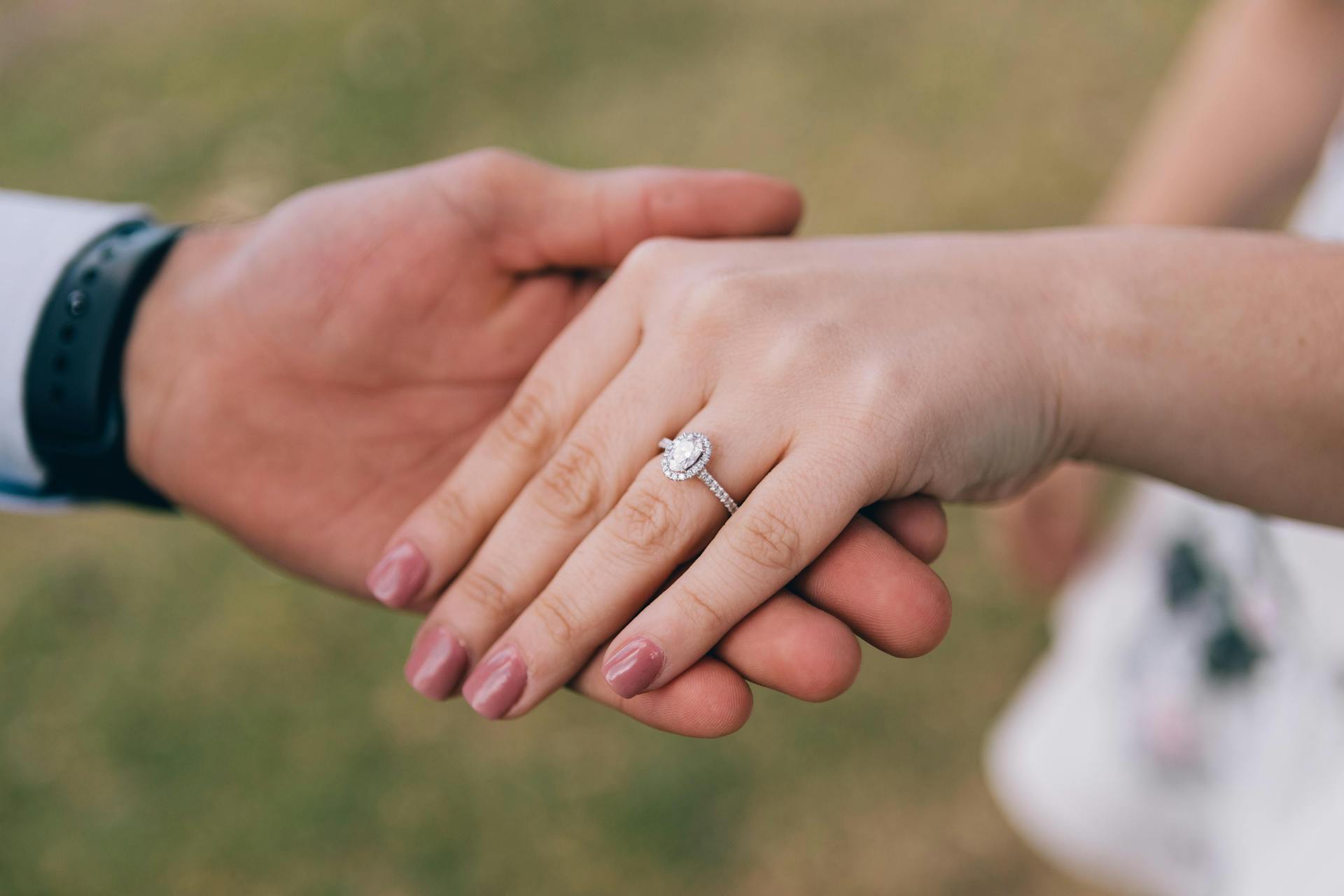 Un homme tenant la main de sa fiancée montrant sa bague de fiançailles | Source : Pexels
