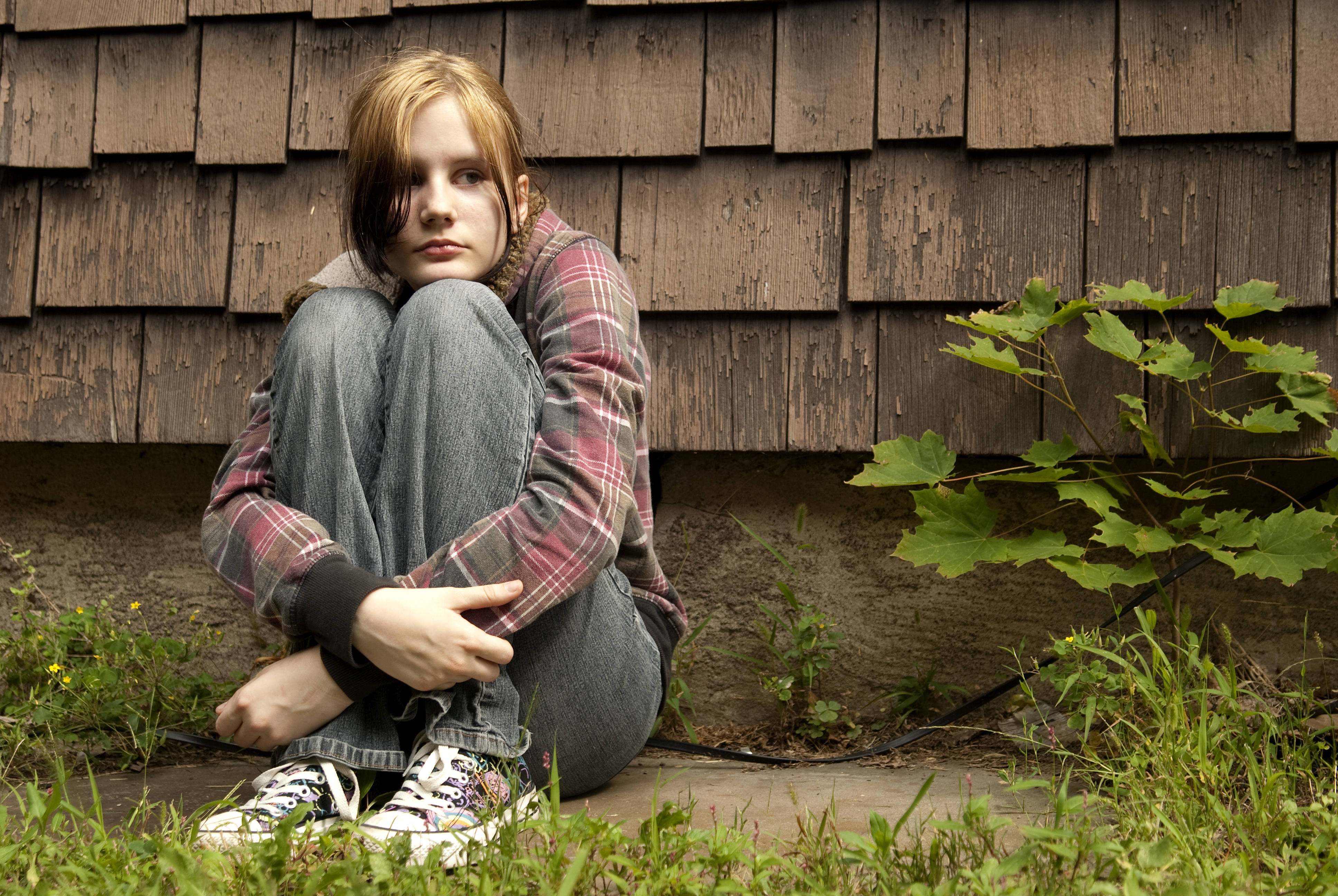 Une fille triste assise par terre | Source : Shutterstock