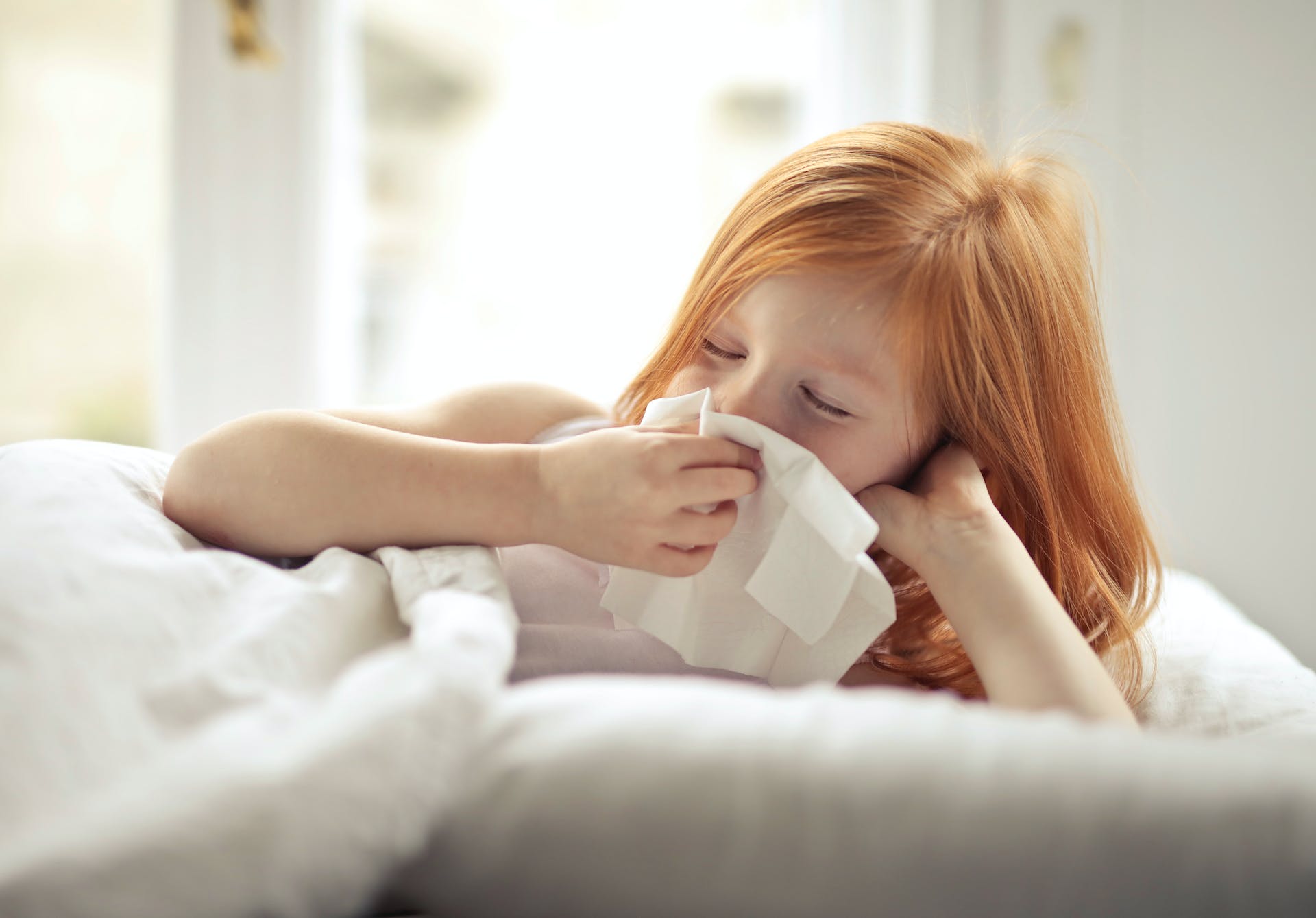 Petite fille s'essuyant le nez avec un mouchoir en papier | Source : Pexels