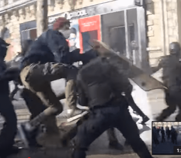 Les manifestants s'attaquent à un policier sur les Champs-Elysées, le 16 mars 2019. | Photo : Youtube/InfoCritiqueWeb