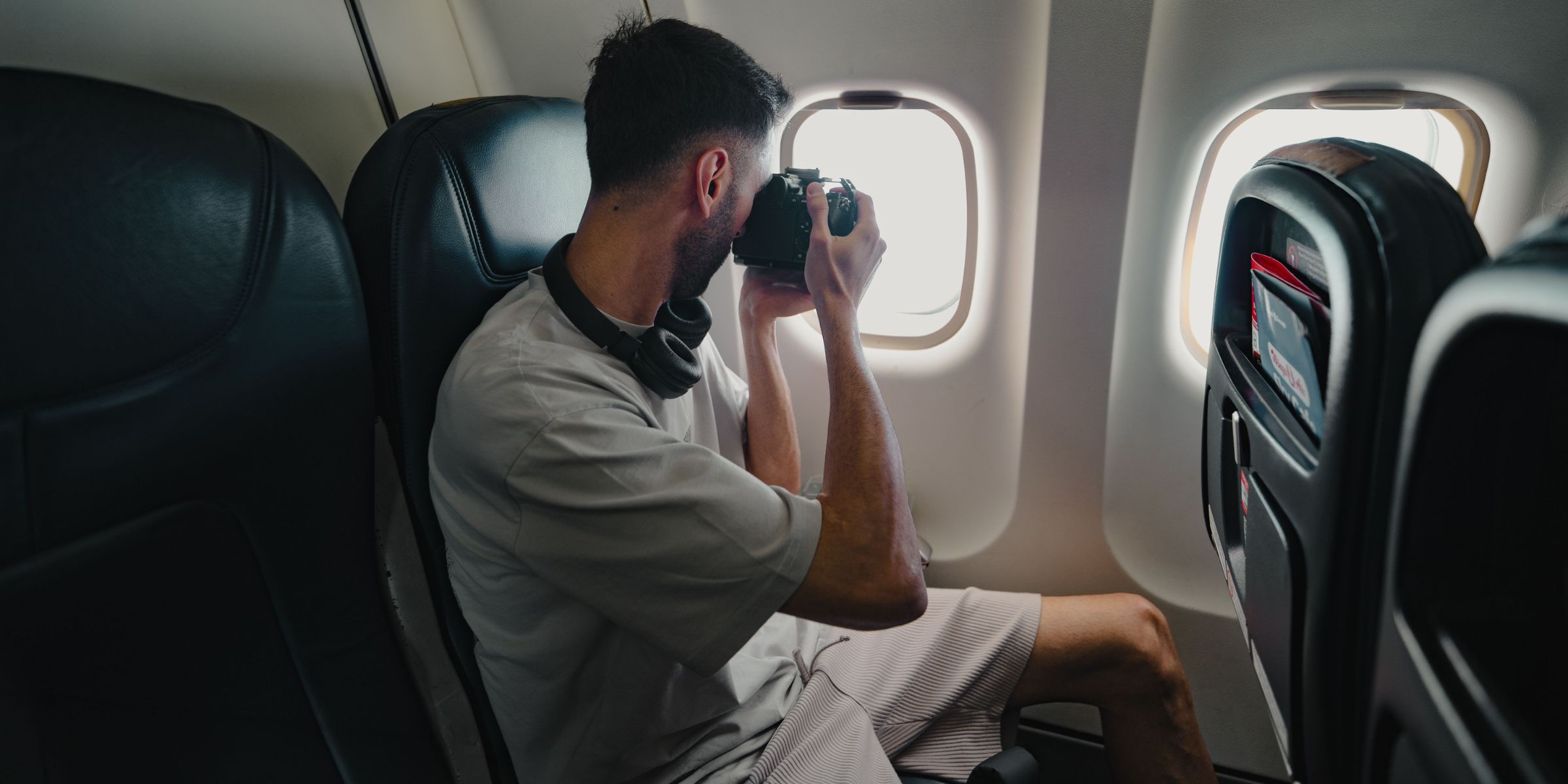 Un homme en train de prendre des photos depuis un avion | Source : Pexels