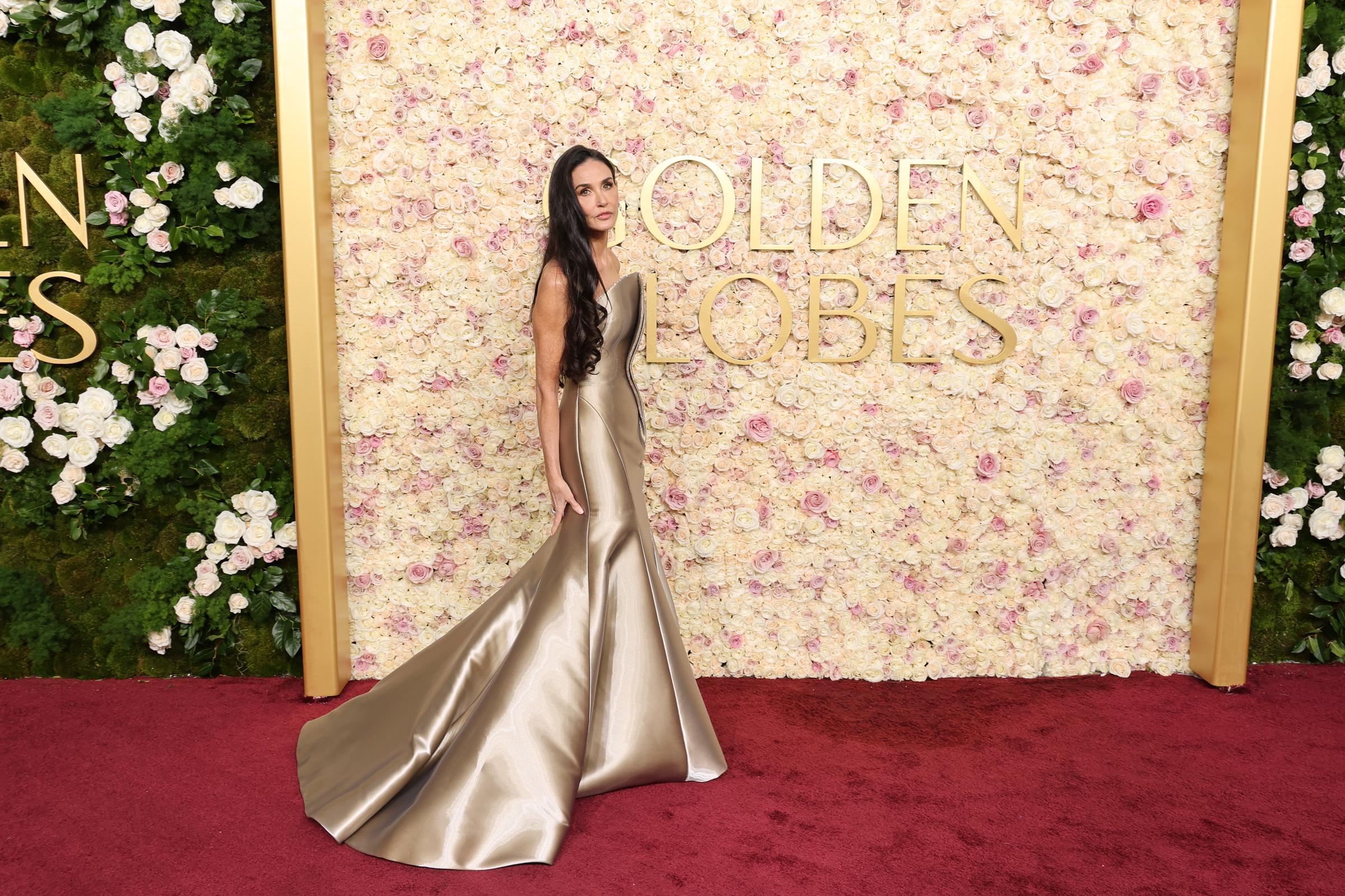 Demi Moore debout devant une toile de fond des Golden Globes. | Source : Getty Images