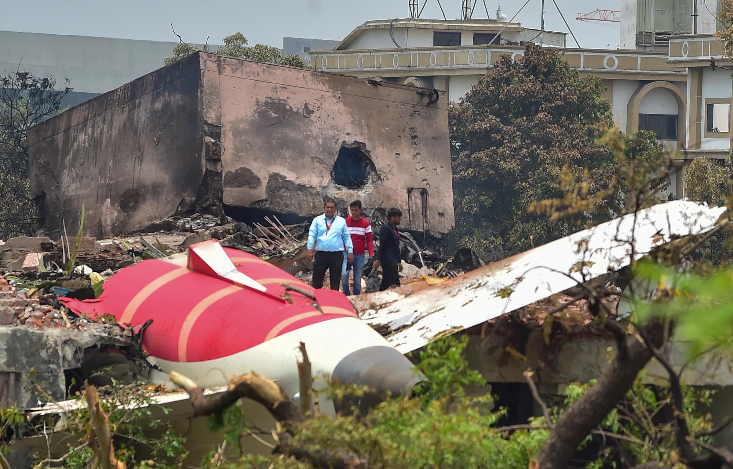 Les responsables de l'enquête se tiennent sur le site du Boeing 787 d'Air India qui s'est écrasé à Ahmedabad, en Inde, le 13 juin 2025 | Source : Getty Images