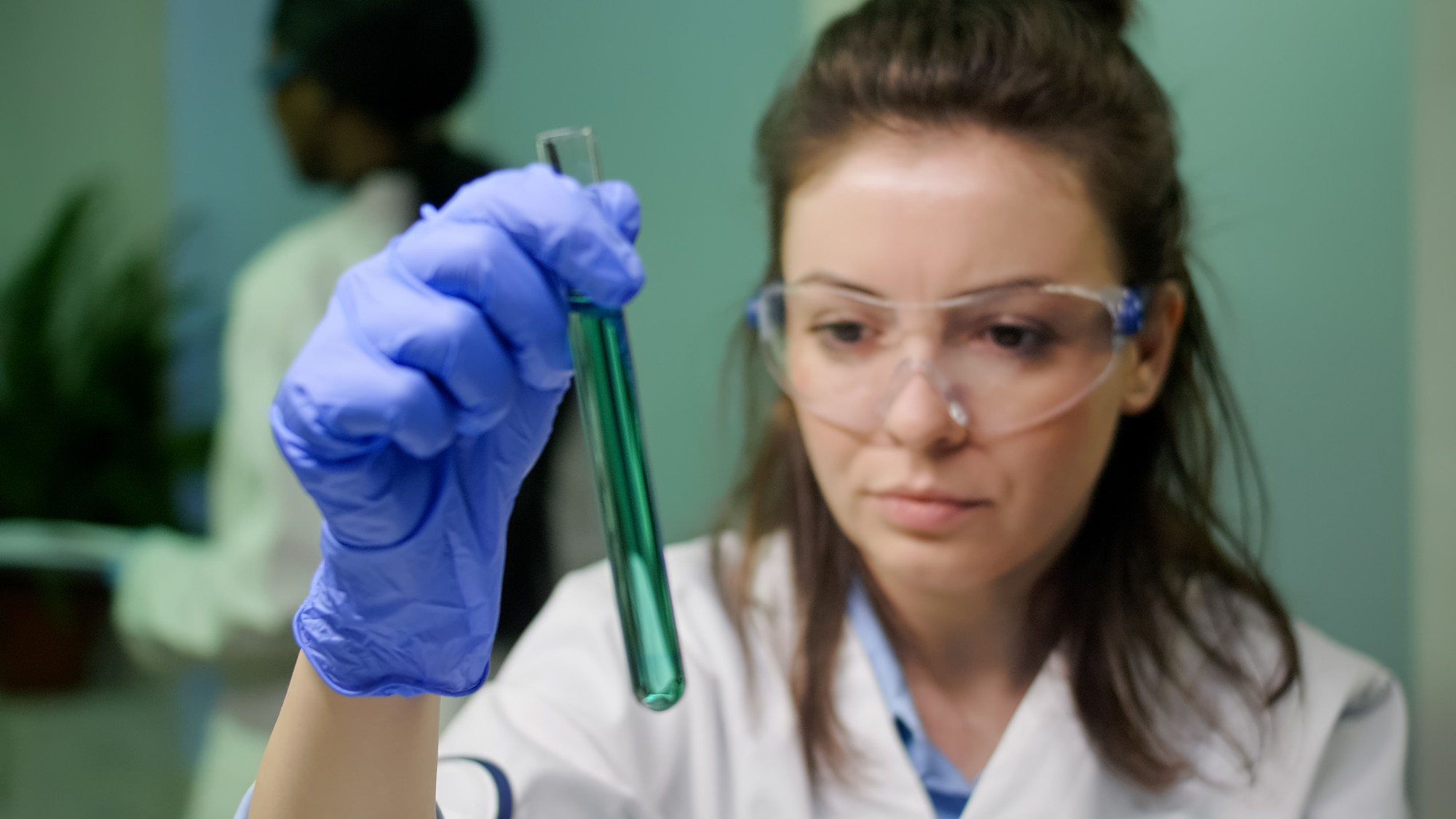 Une personne tenant un tube à essai dans un laboratoire | Source : Freepik
