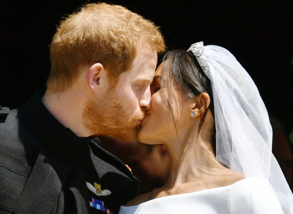 Le Prince Harry et sa femme Meghan Markle, Duchesse de Sussex, s'embrassent. | Getty Images