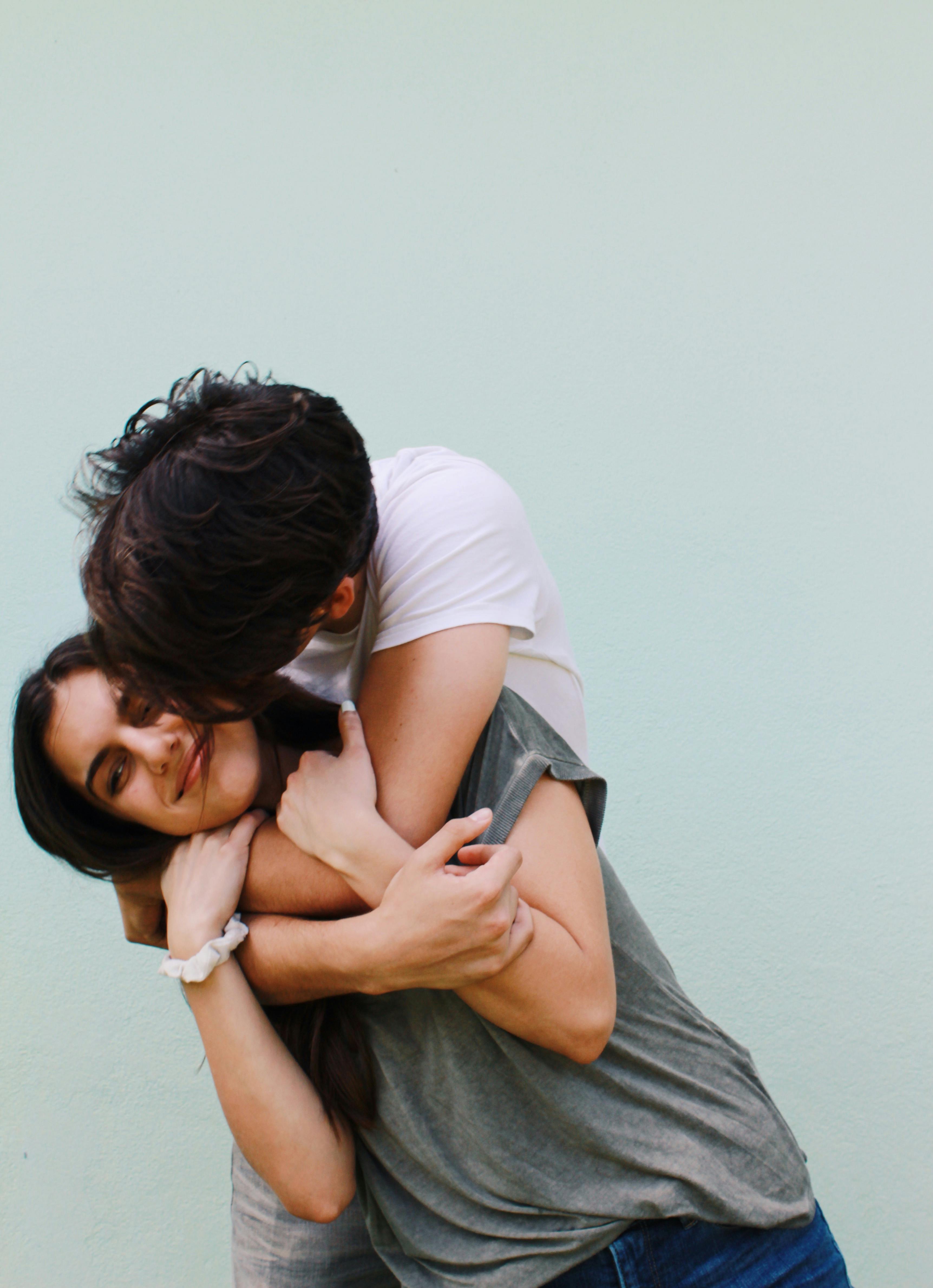 Un homme heureux embrassant et serrant dans ses bras une femme à l'air mécontent | Source : Pexels