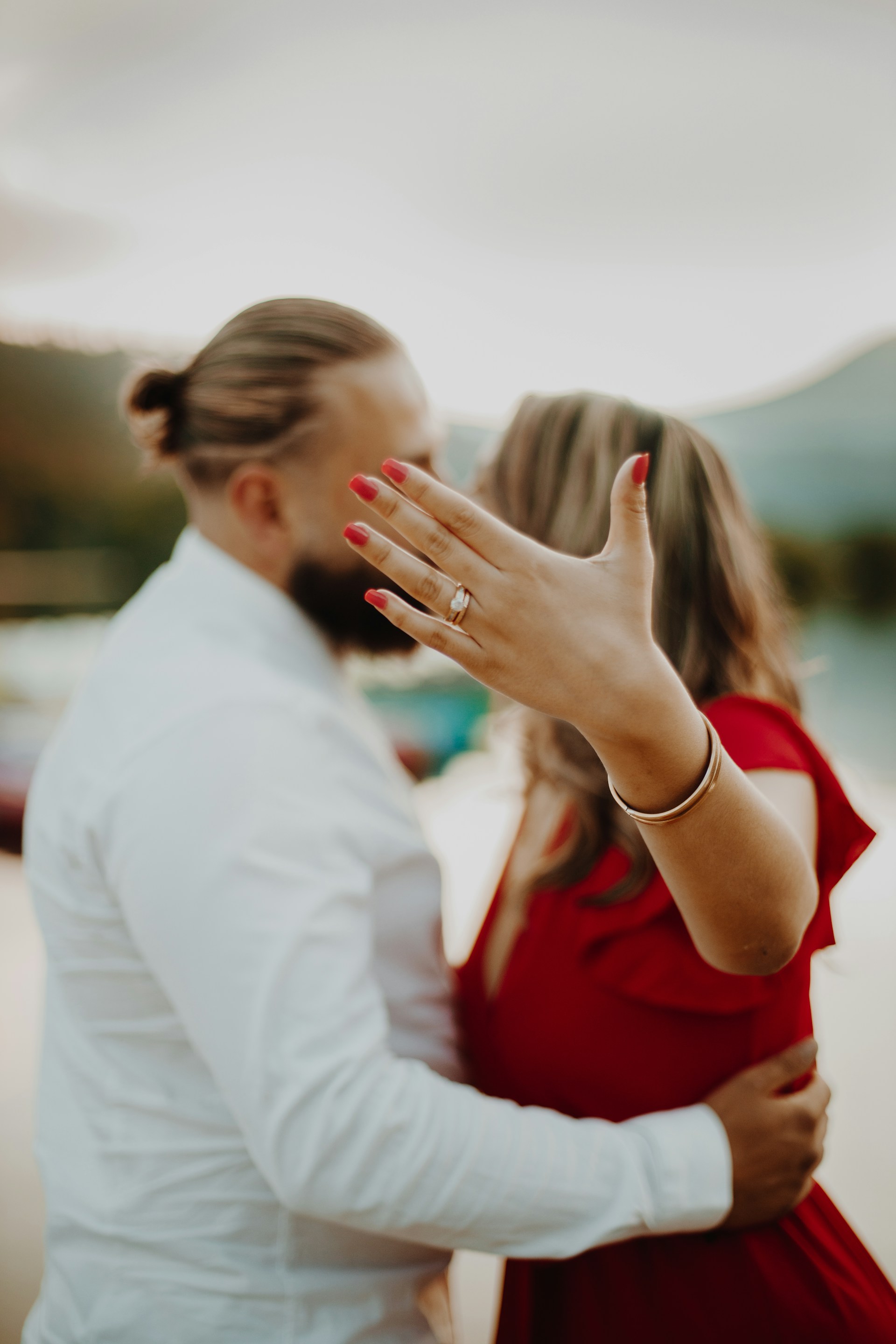 Un homme embrassant sa partenaire tandis qu'elle exhibe sa bague de fiançailles | Source : Unsplash