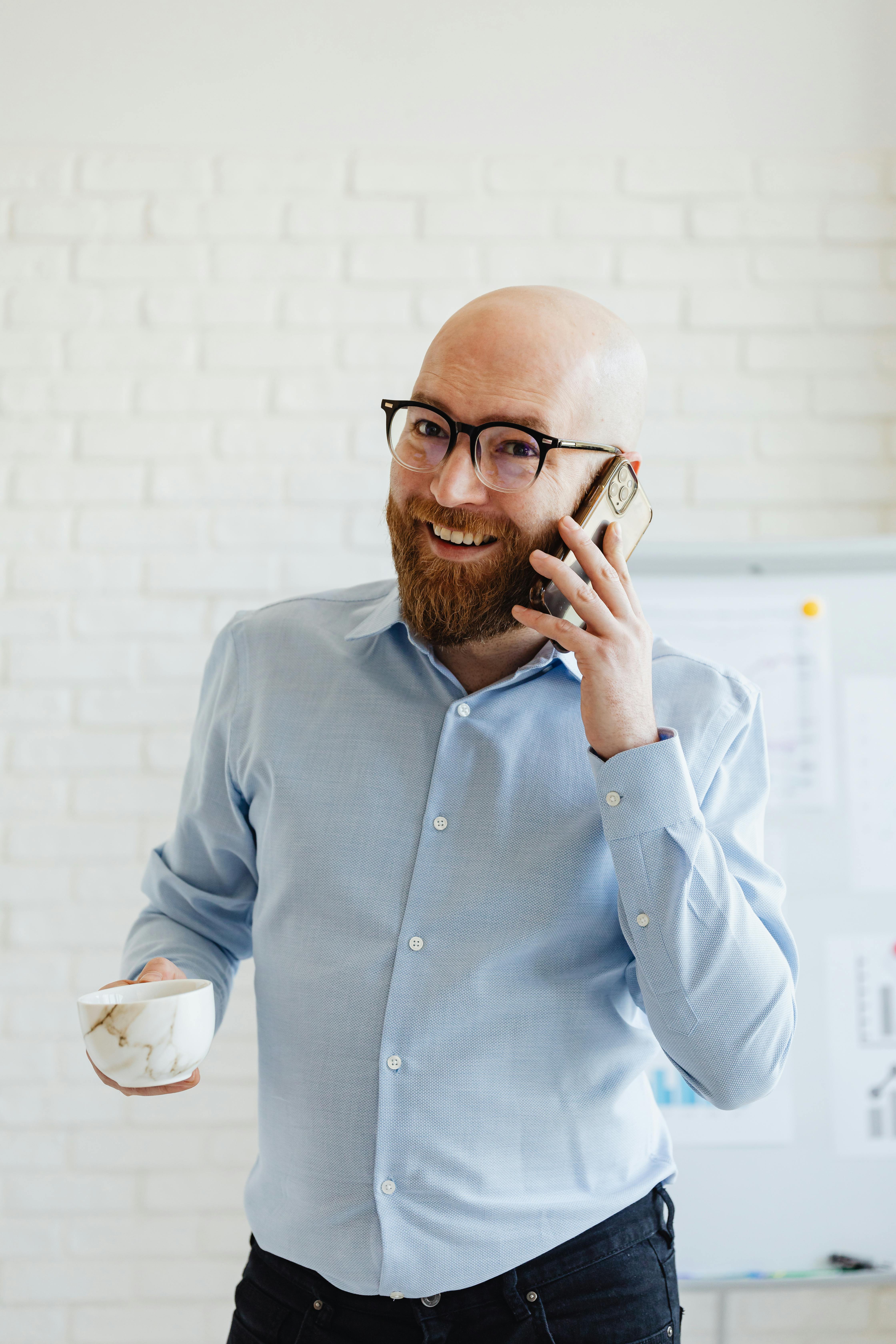 Un homme souriant au téléphone | Source : Pexels