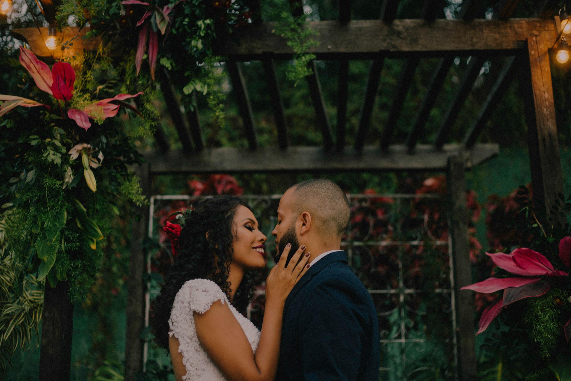 Un couple debout sous une arche de jardin couverte de fleurs | Source : Pexels