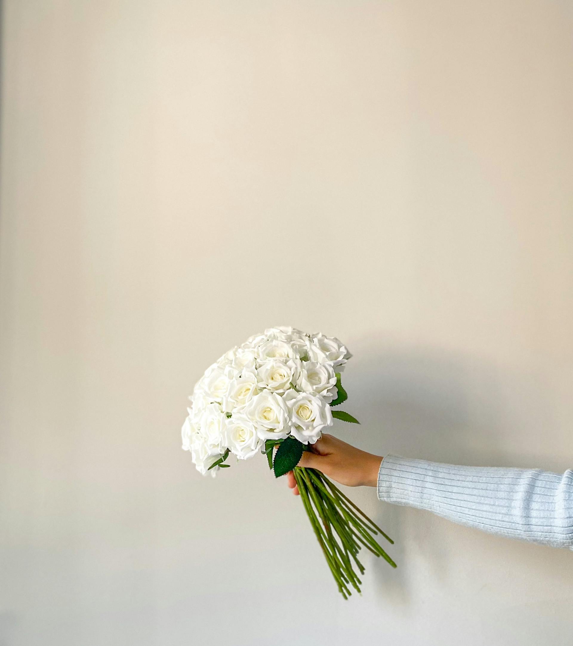 Une femme tenant un bouquet de roses blanches | Source : Pexels