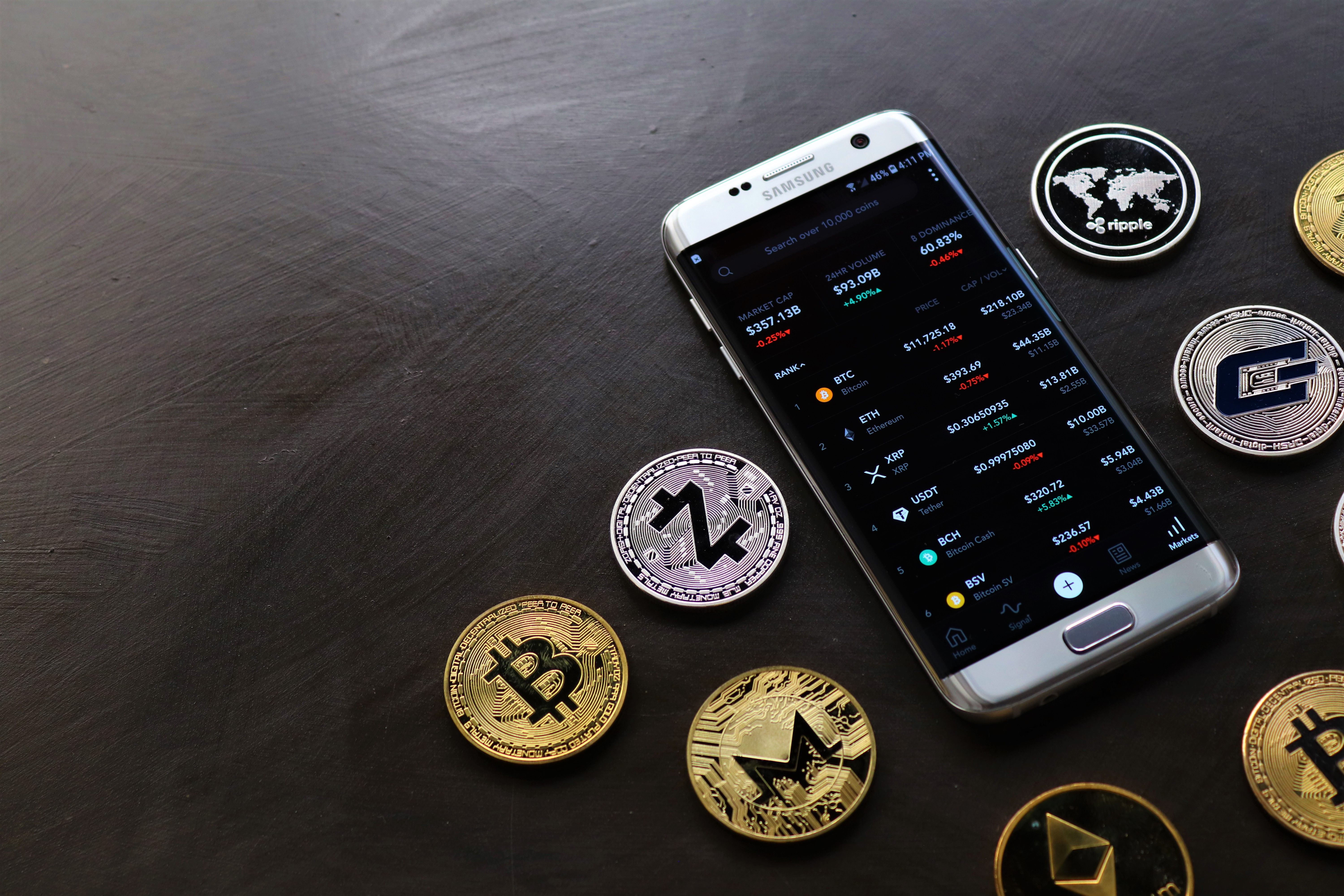 Une collection de pièces de monnaie et un smartphone | Source : Pexels