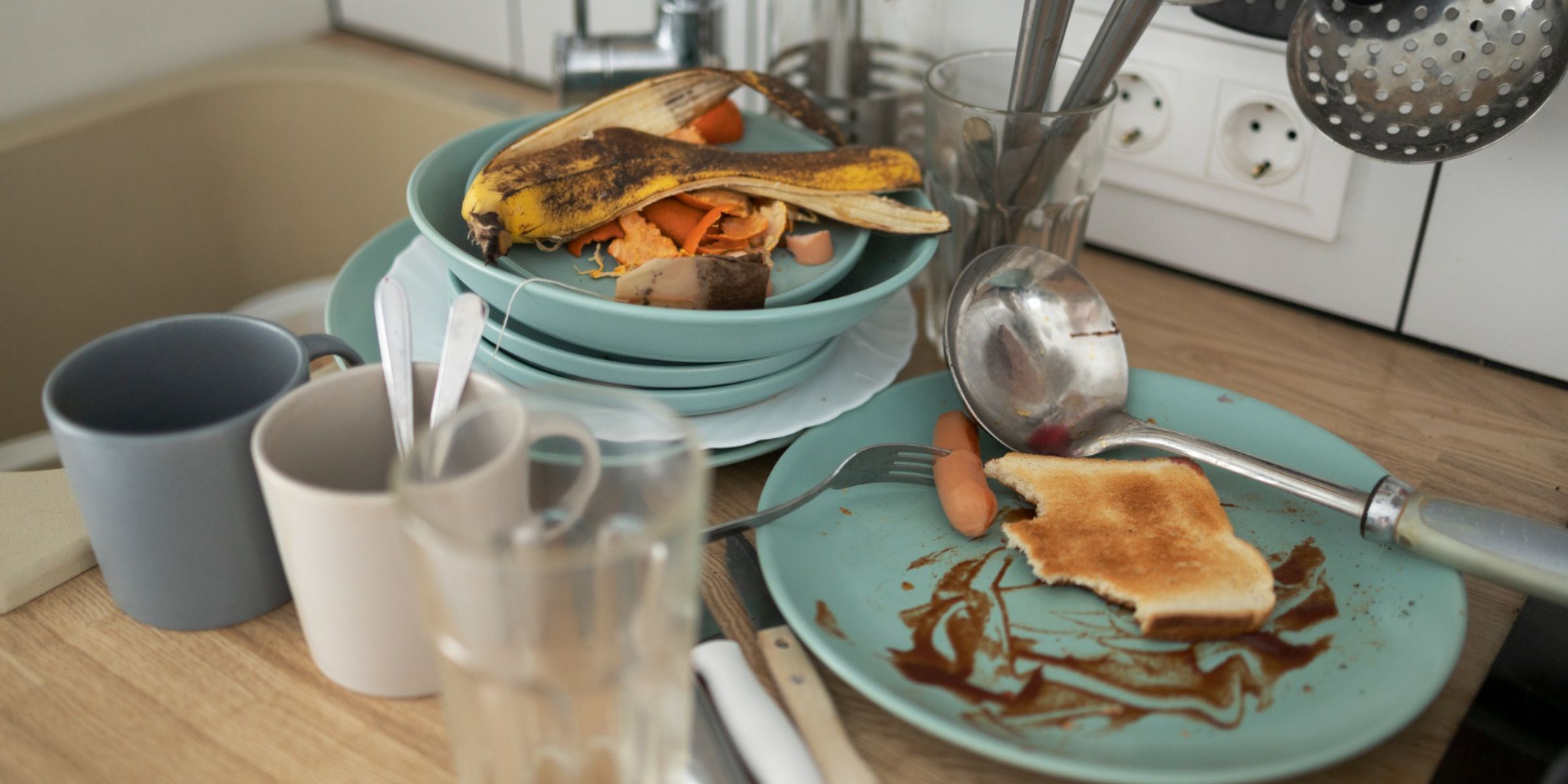 Vaisselle sale près de l'évier de la cuisine | Source : Freepik