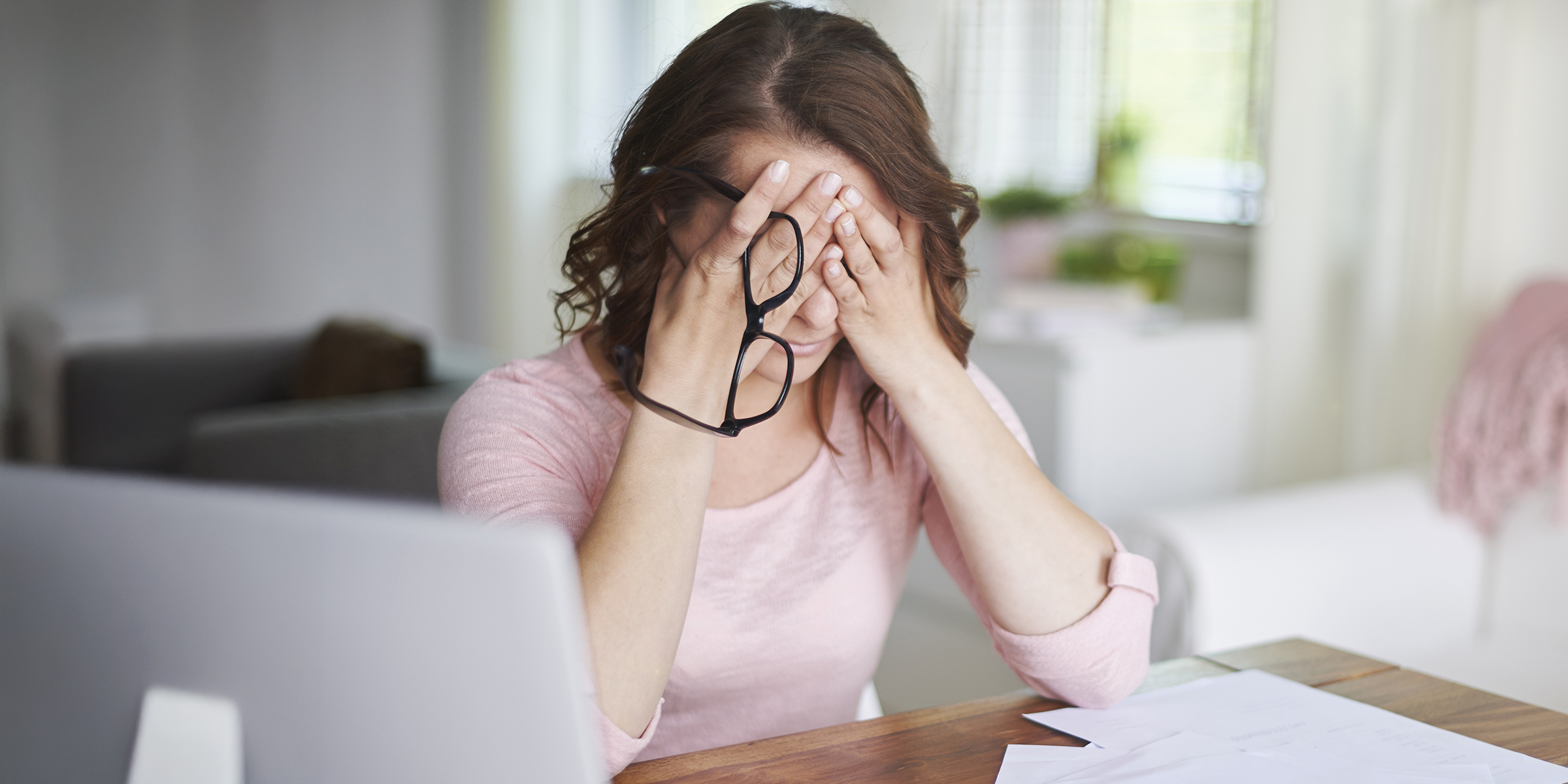 Une femme inquiète assise, la tête dans les mains | Source : Shutterstock
