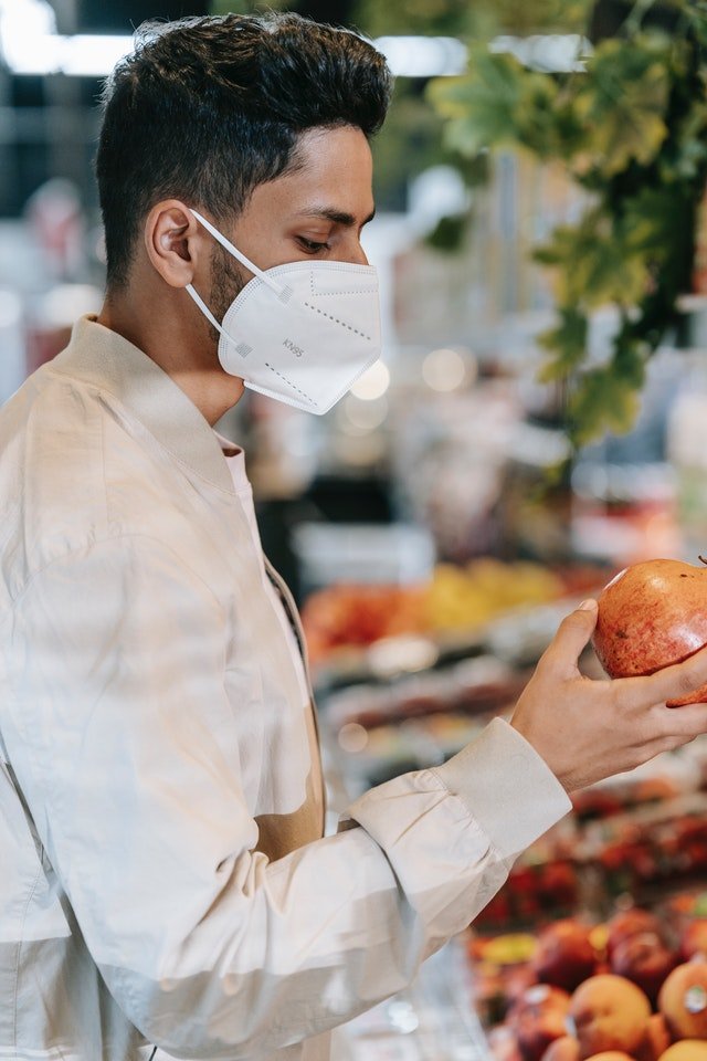 Un homme au supermarché portant un masque | Photo : Getty Images.