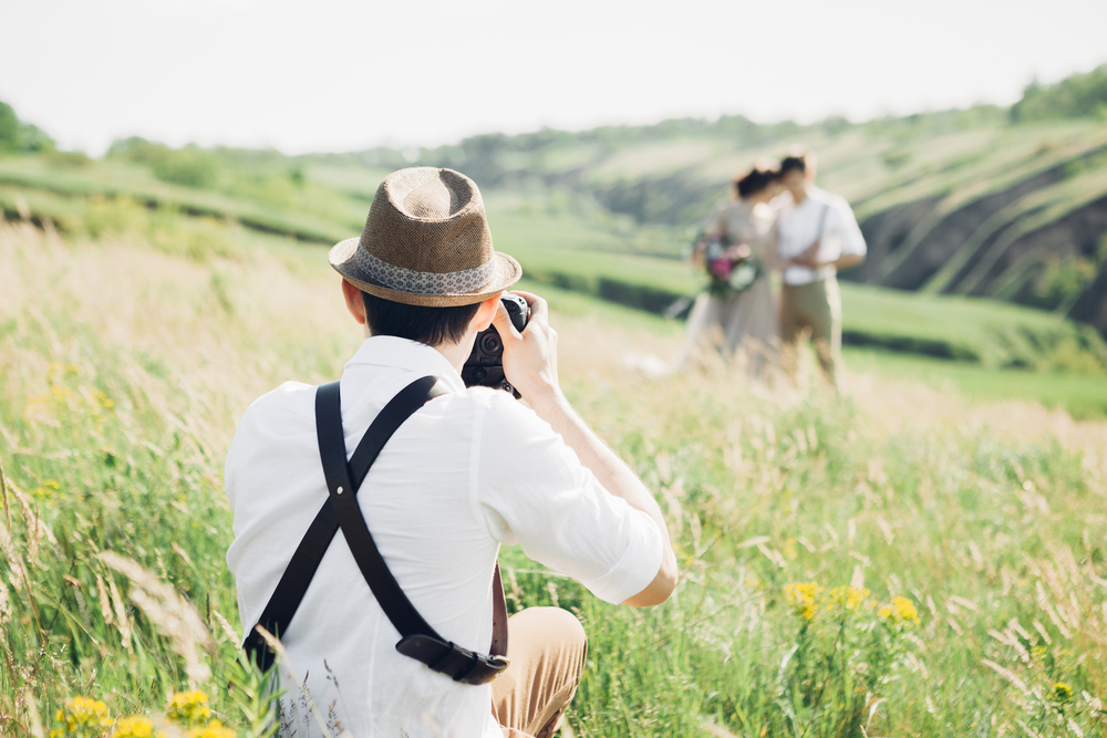 Fotógrafo de bodas toma fotos de los novios | Fuente: Shutterstock