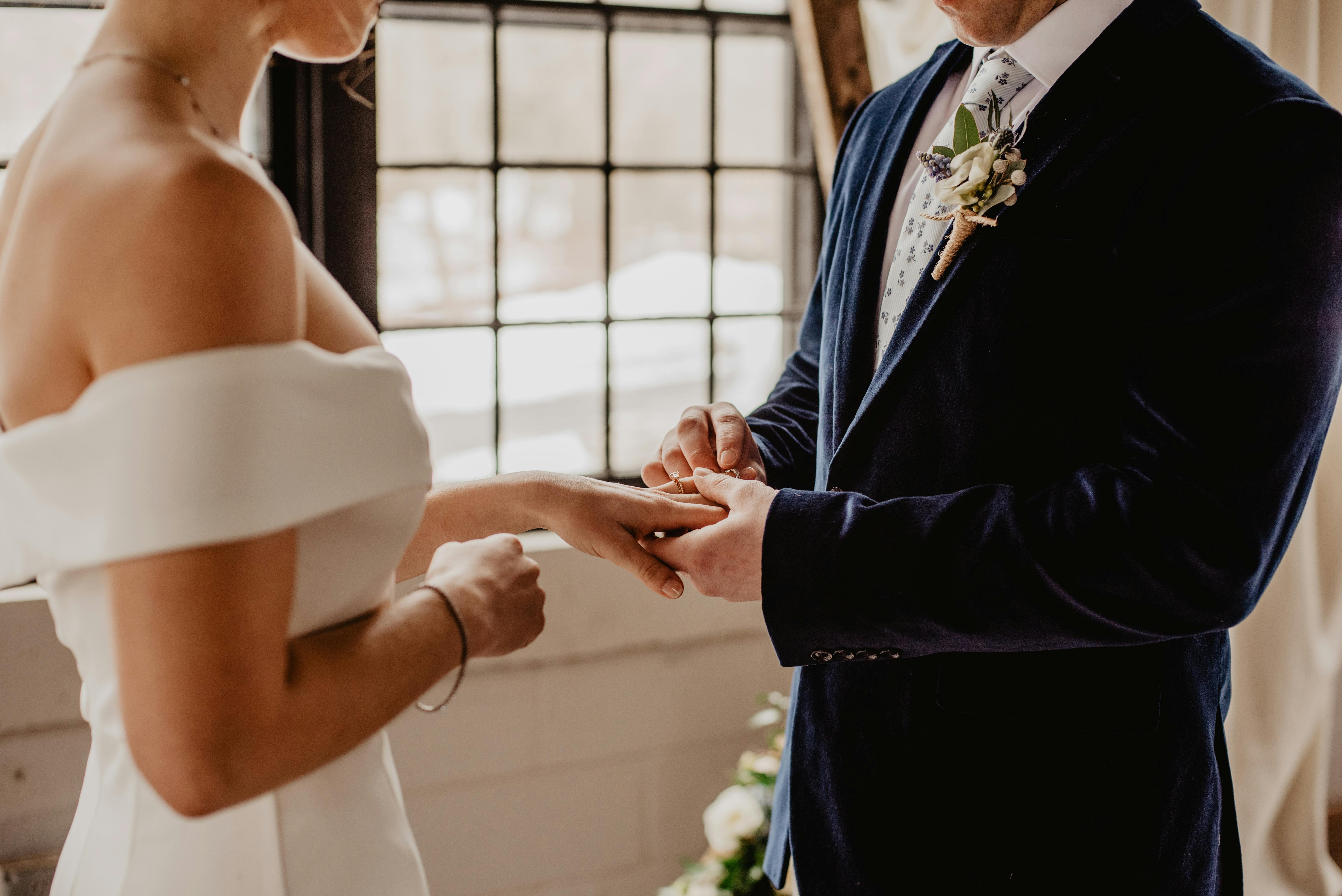 Une mariée et un marié qui échangent leurs anneaux | Source : Pexels