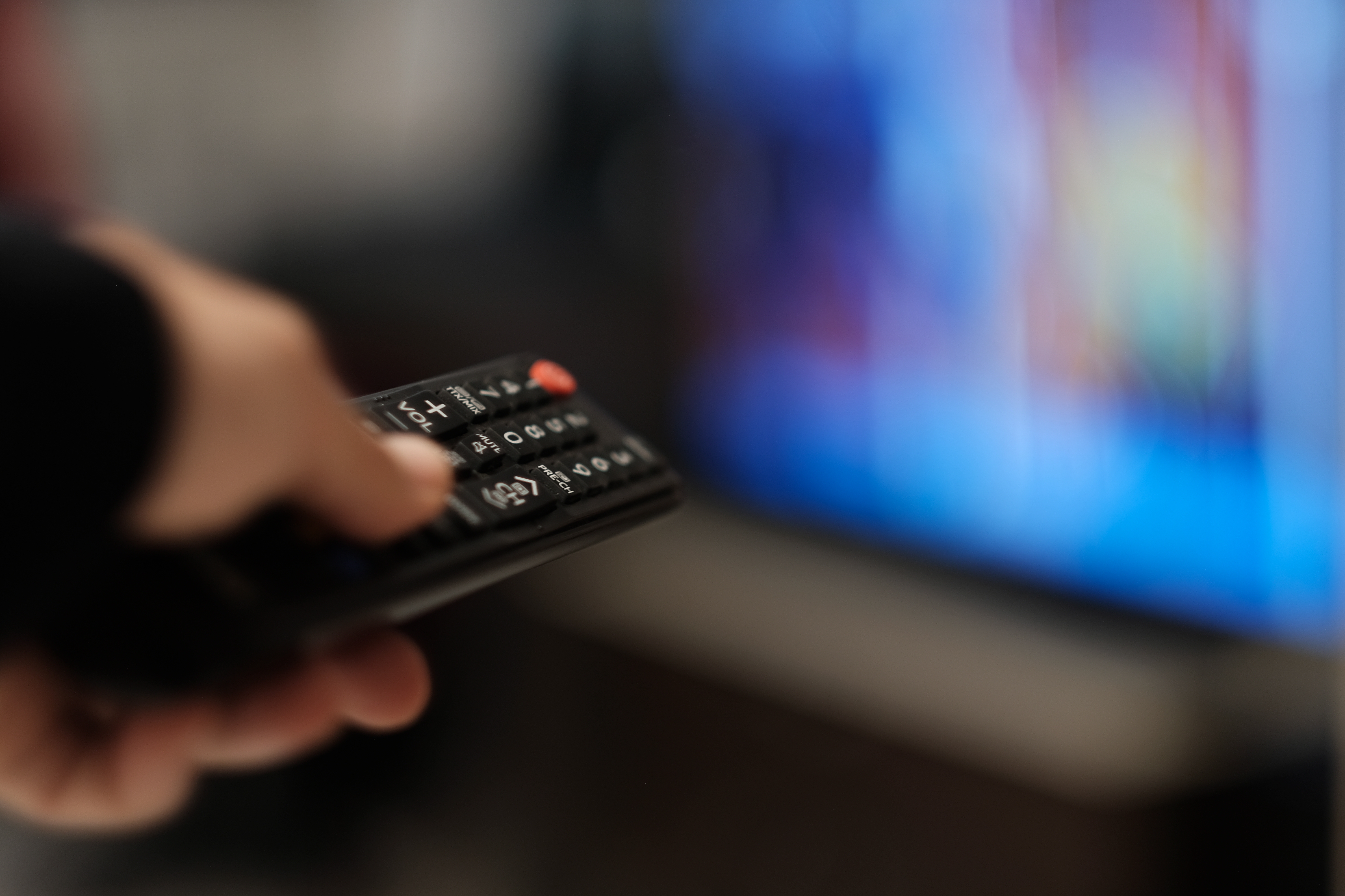 Une personne pointant une télécommande sur une télé | Source : Getty Images