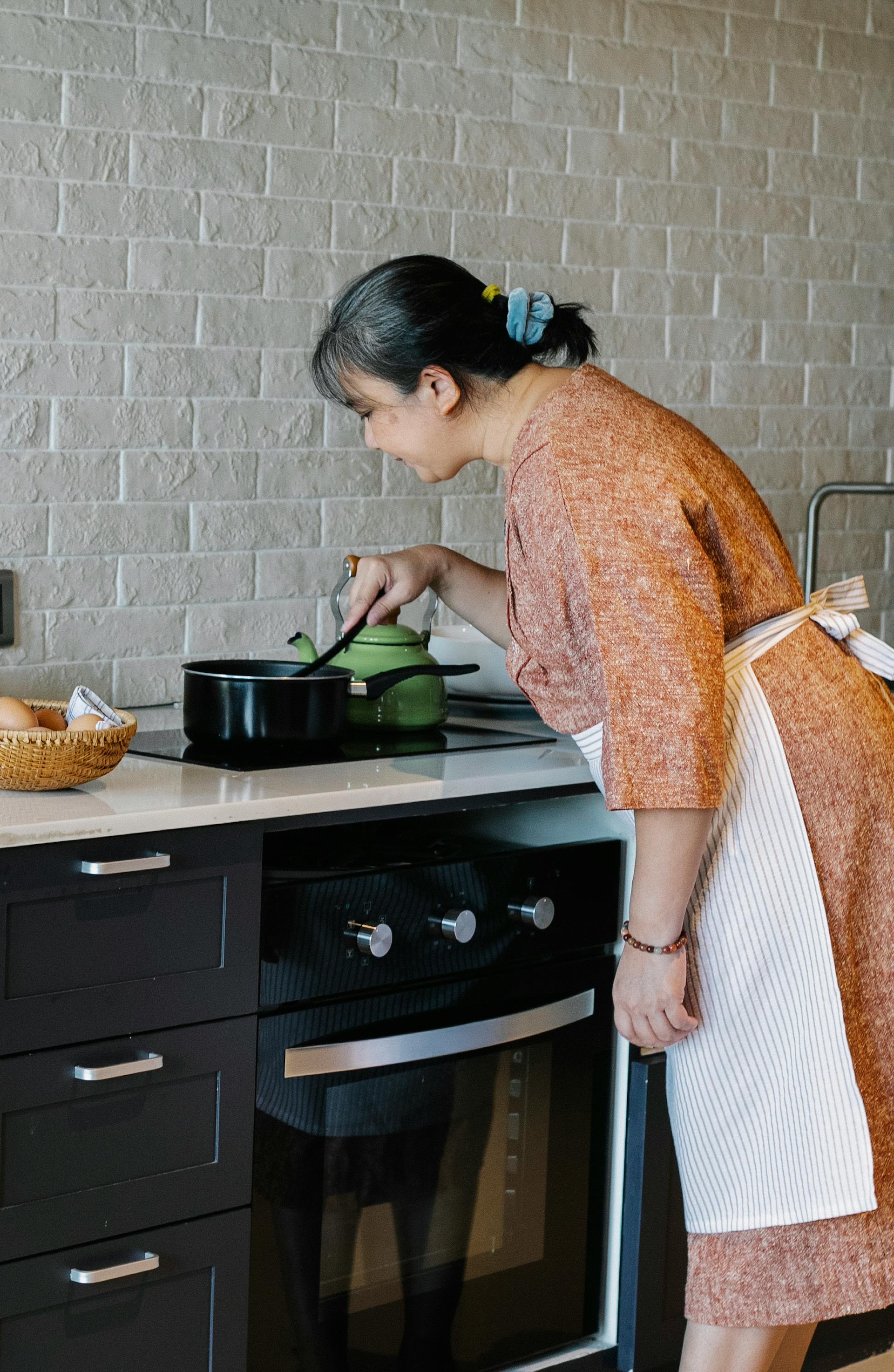 Une femme âgée remuant une casserole dans la cuisine | Source : Pexels