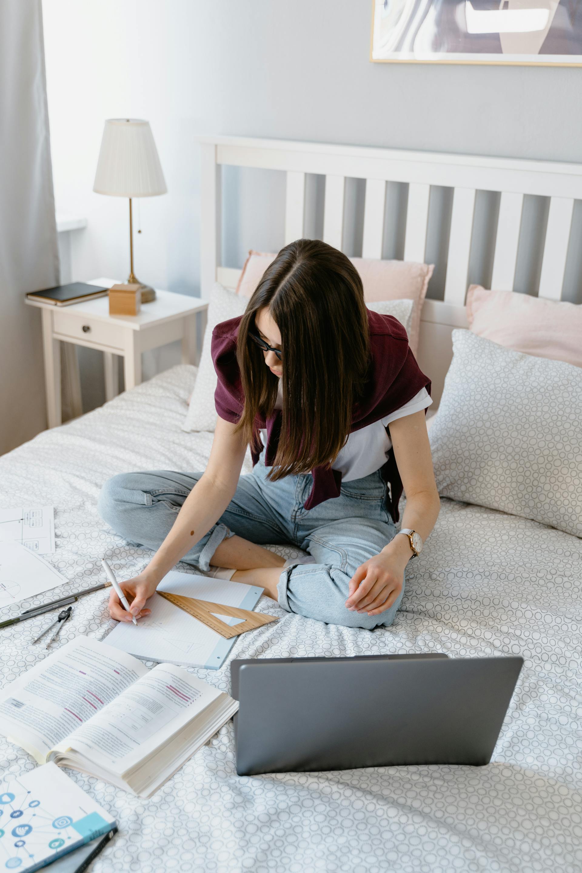 Une femme qui étudie tout en étant assise dans son lit | Source : Pexels