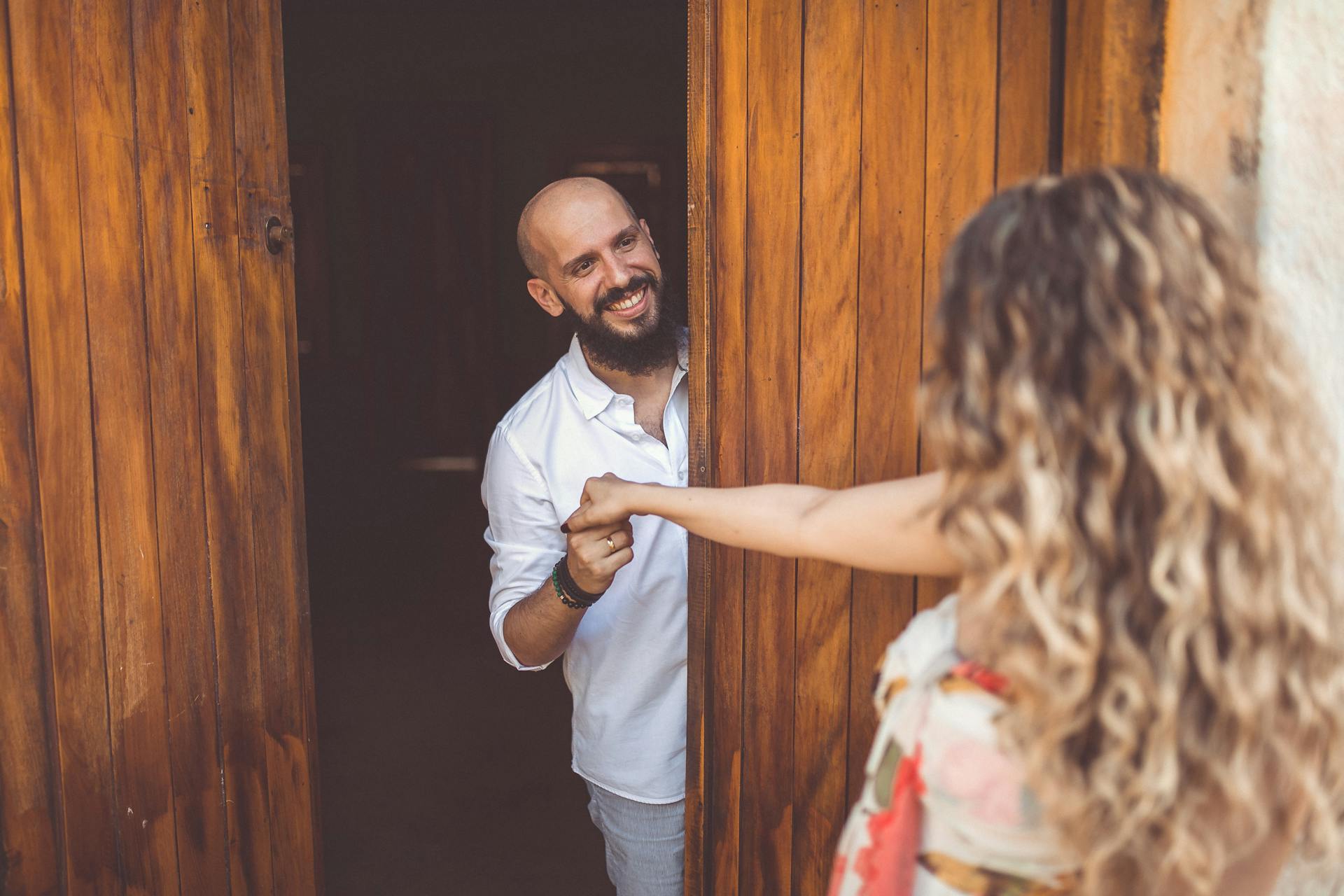 Un homme heureux accueillant une femme dans sa maison | Source : Pexels