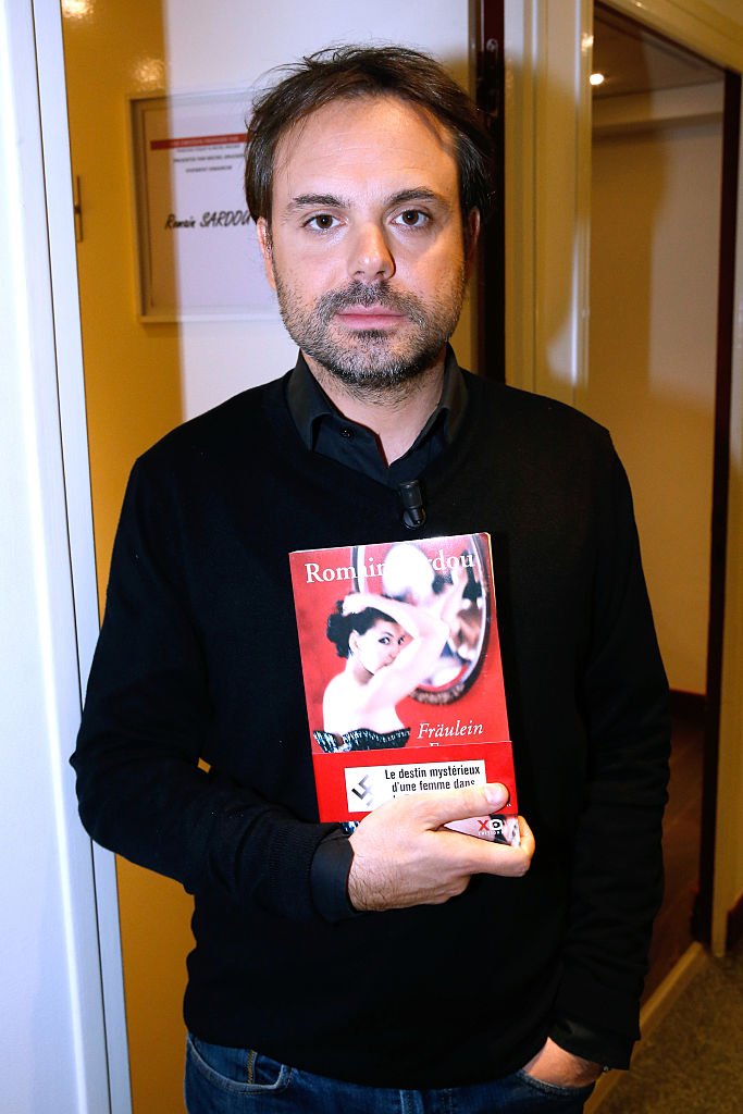 Romain Sardou présente ses livres “Fraulein France” lors de l'émission de télévision française “Vivement Dimanche'' au Pavillon Gabriel le 12 novembre 2014 à Paris. | Photo : Getty Images 