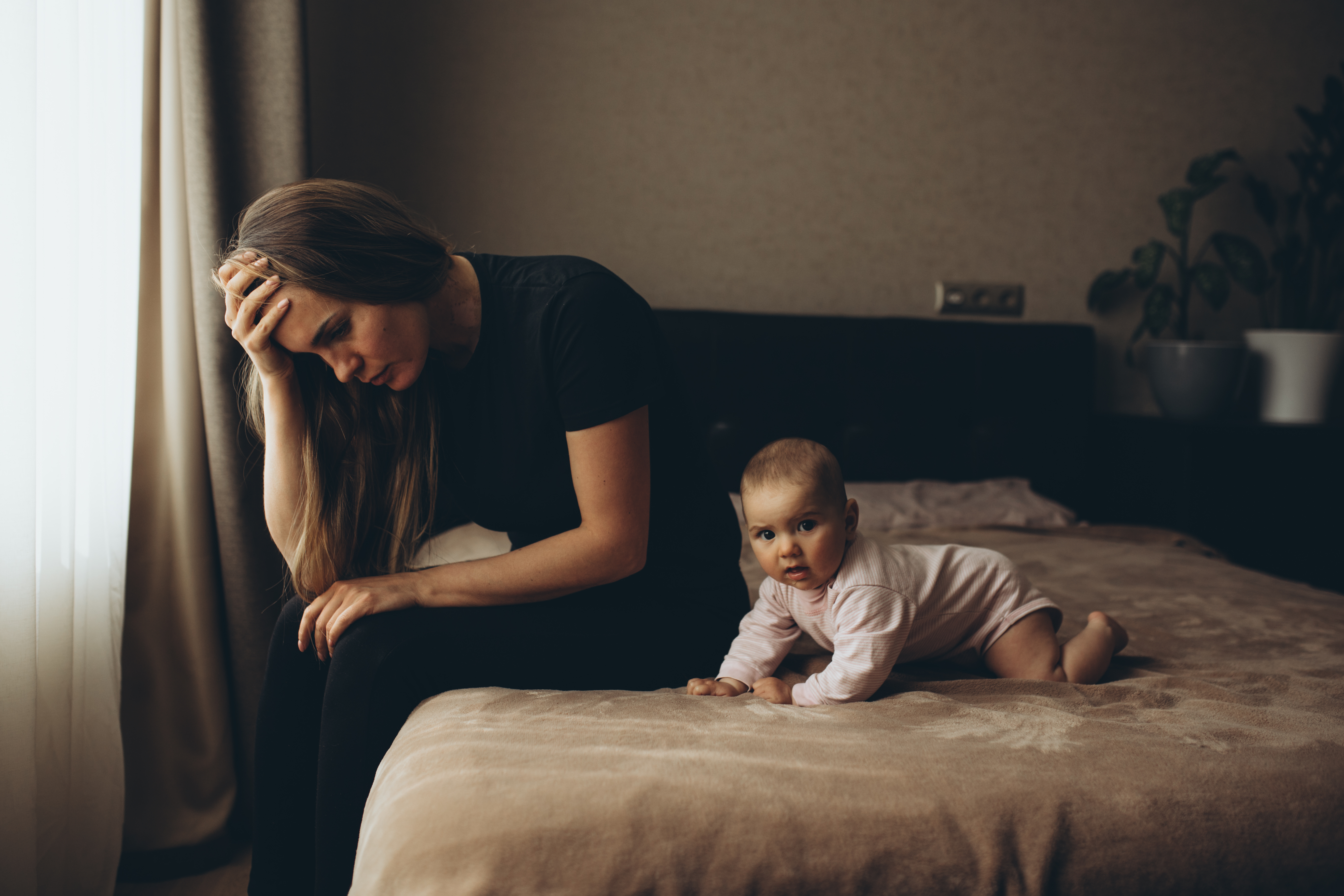 Une femme en détresse photographiée à côté d'un bébé sur le lit | Source : Getty Images