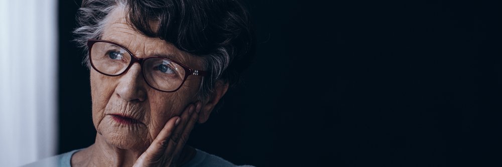 Une vieille dame seule, atteinte de la maladie d'Alzheimer, qui regarde par la fenêtre. | Source : Shutterstock
