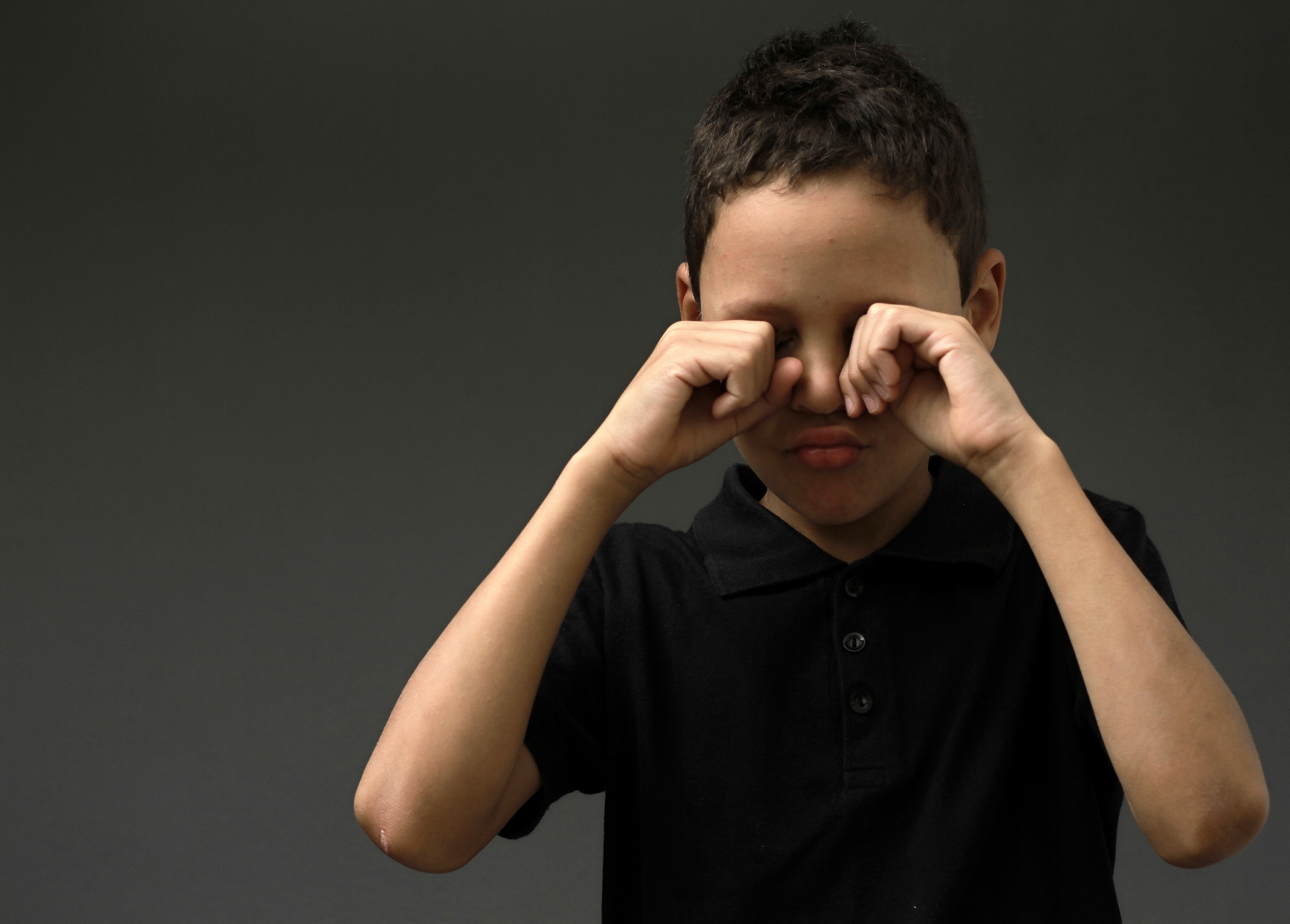 Un garçon se frottant les yeux | Source : Shutterstock