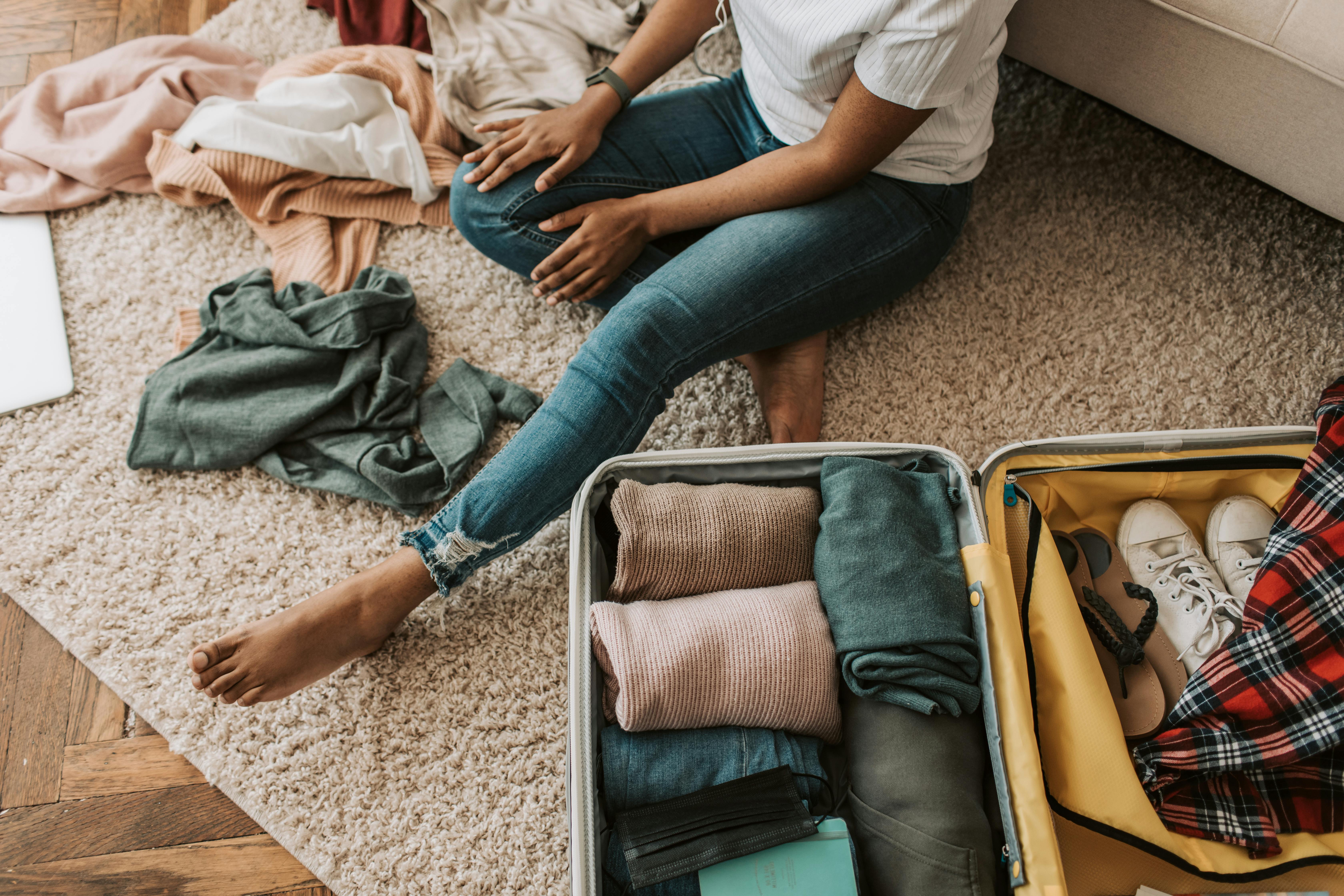 Une femme rangeant ses vêtements et sa valise | Source : Pexels