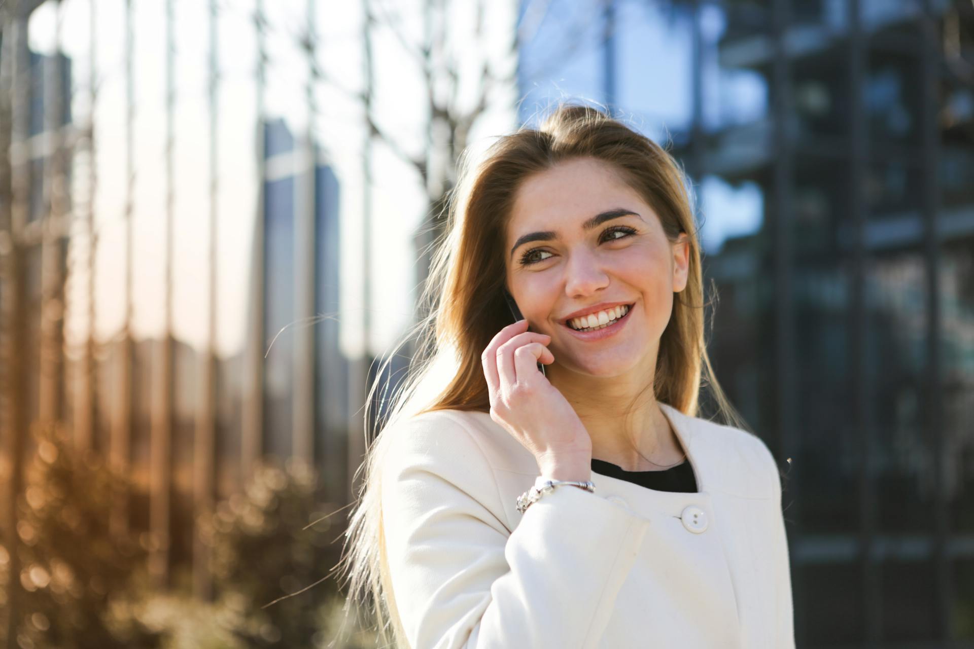 Une femme souriante qui parle au téléphone | Source : Pexels