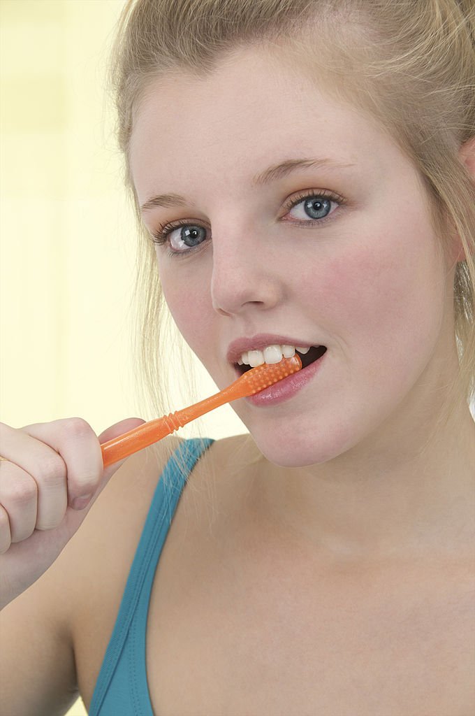 Une femme tenant une brosse à dent | source : Getty Images