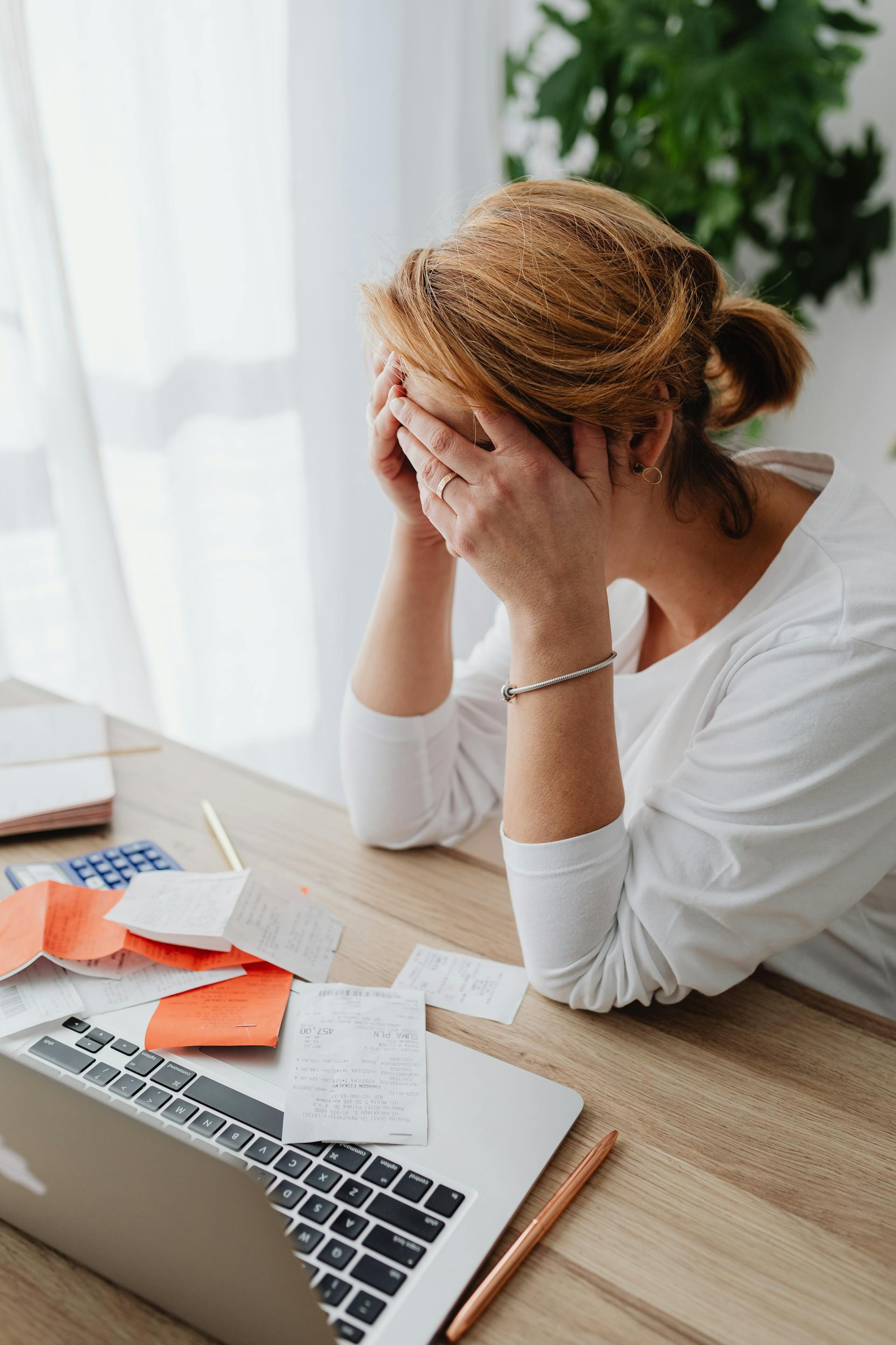 Une femme bouleversée assise à un bureau | Source : Pexels